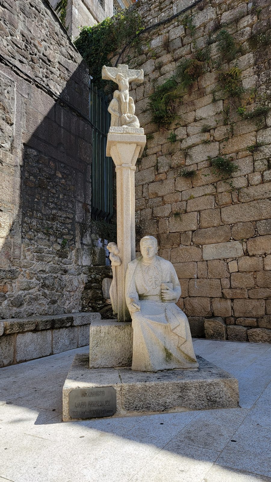 Stone cross by the old wall in Tui