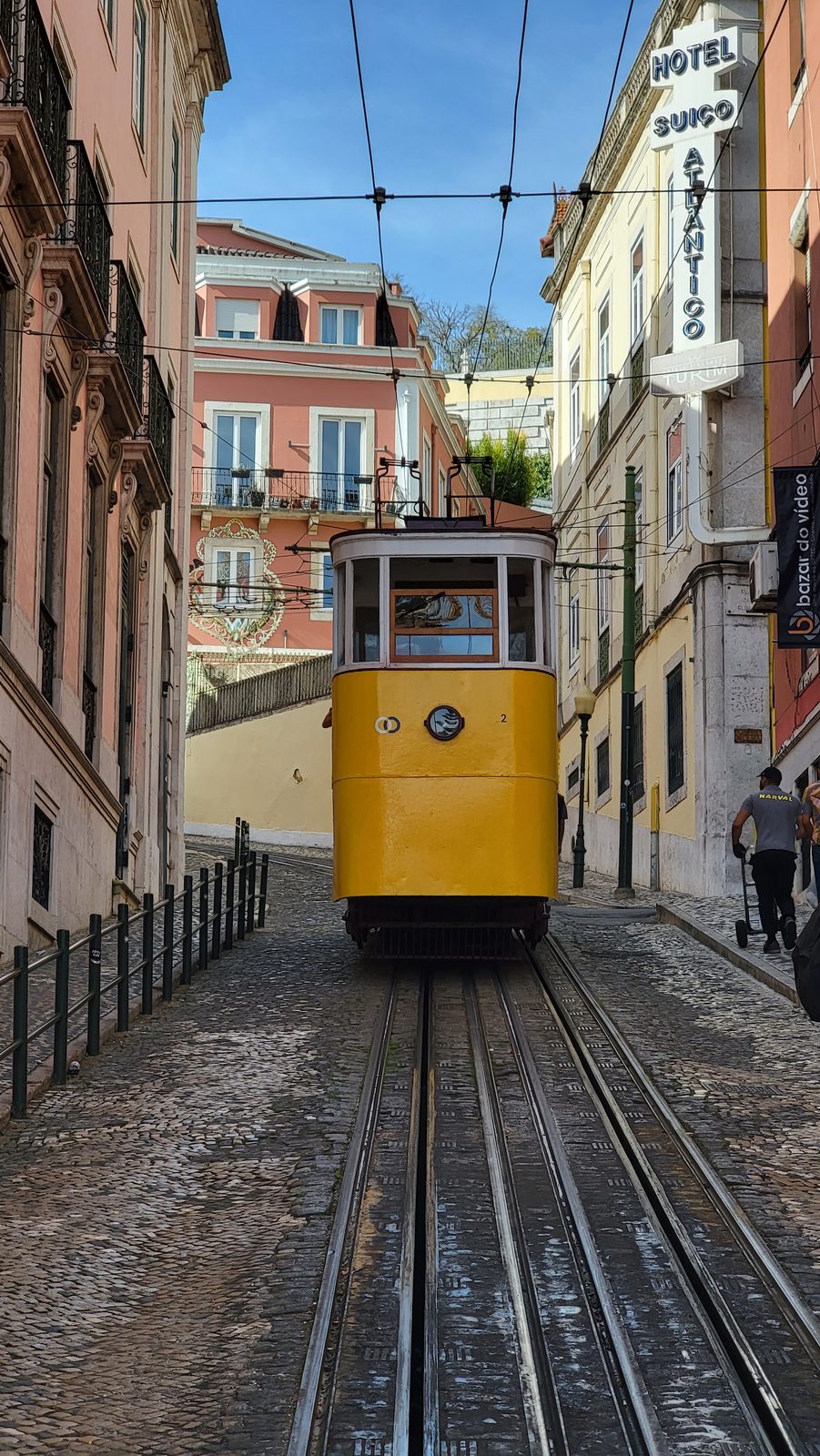 A yellow Elevador da Glória car by Praça dos Restauradores