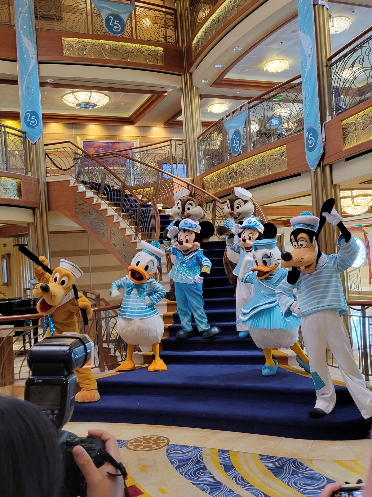 Mickey, Minnie, Donald, Daisy, Goofy, Pluto, Chip and Dale in their Silver Anniversary outfits on the Lobby Atrium staircase