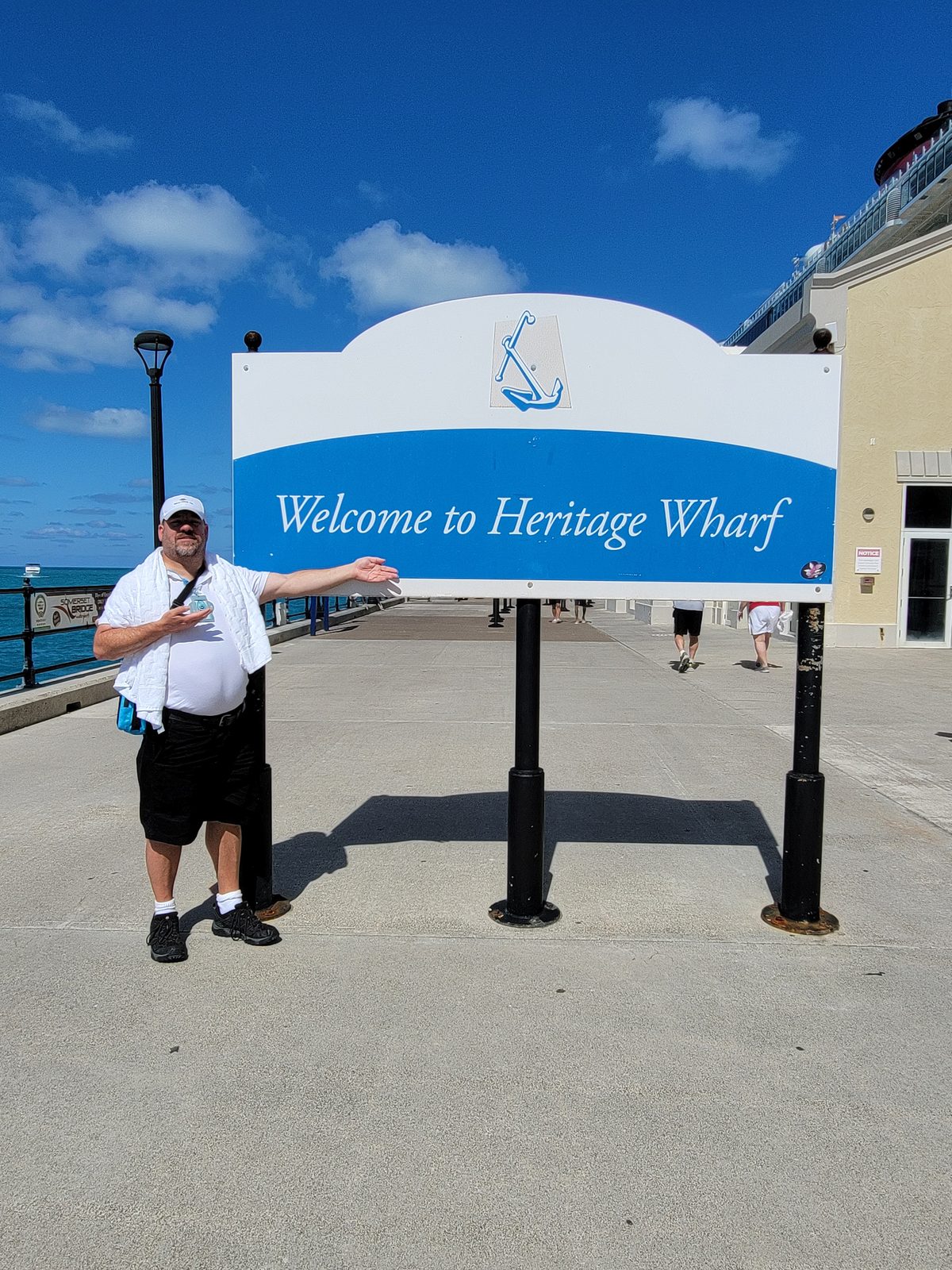 Michael at the Heritage Wharf sign in Bermuda