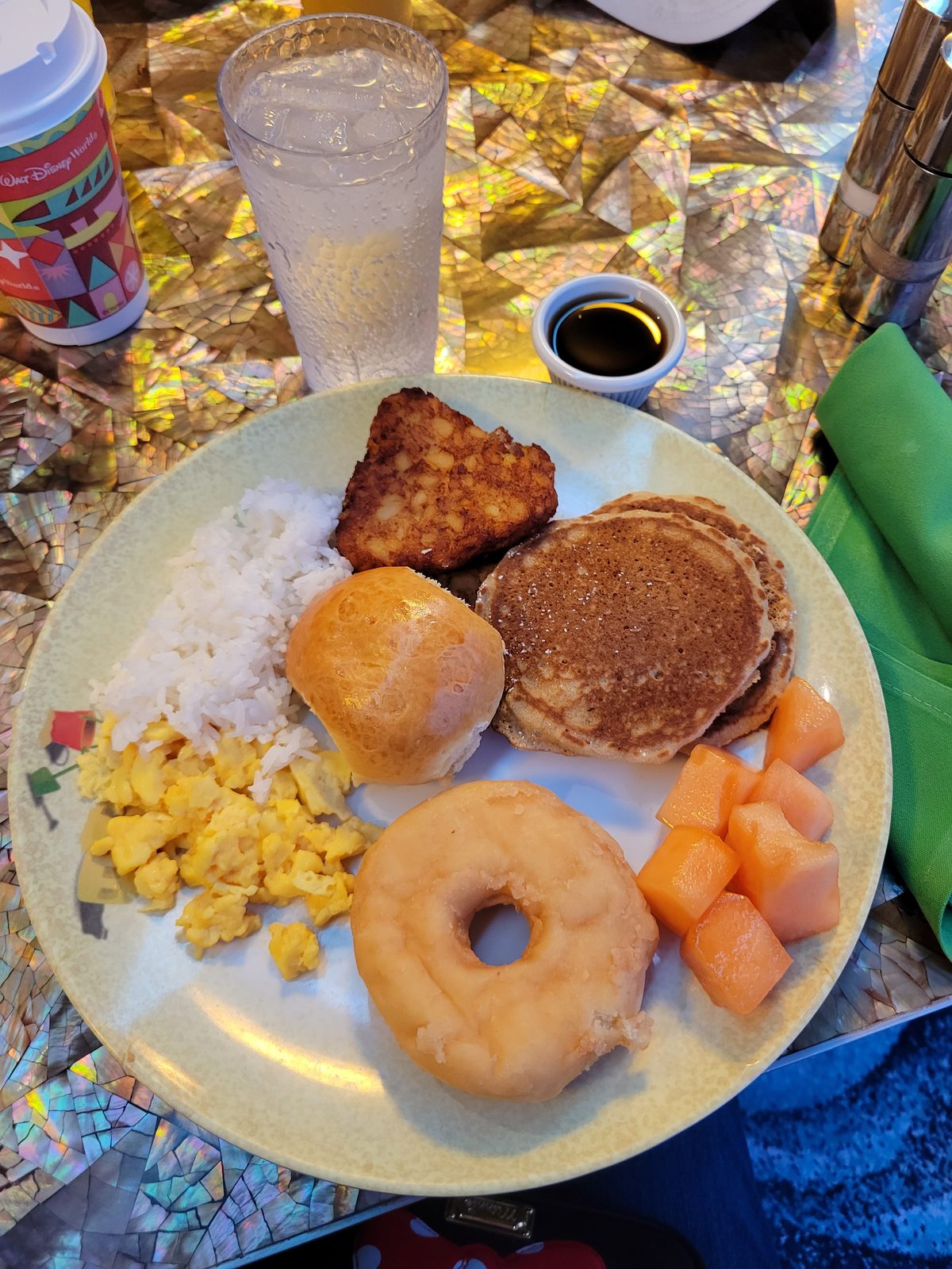 Breakfast plate with a pancake, eggs and a donut