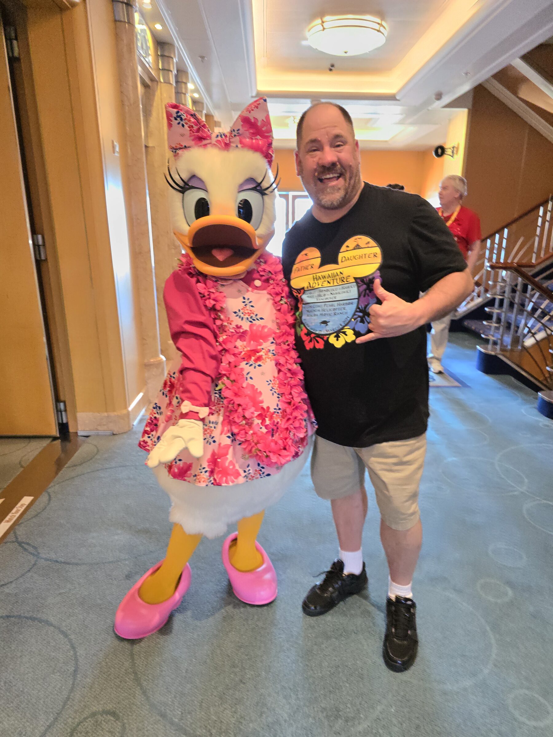 Daisy in her pink aloha dress and lei & Michael