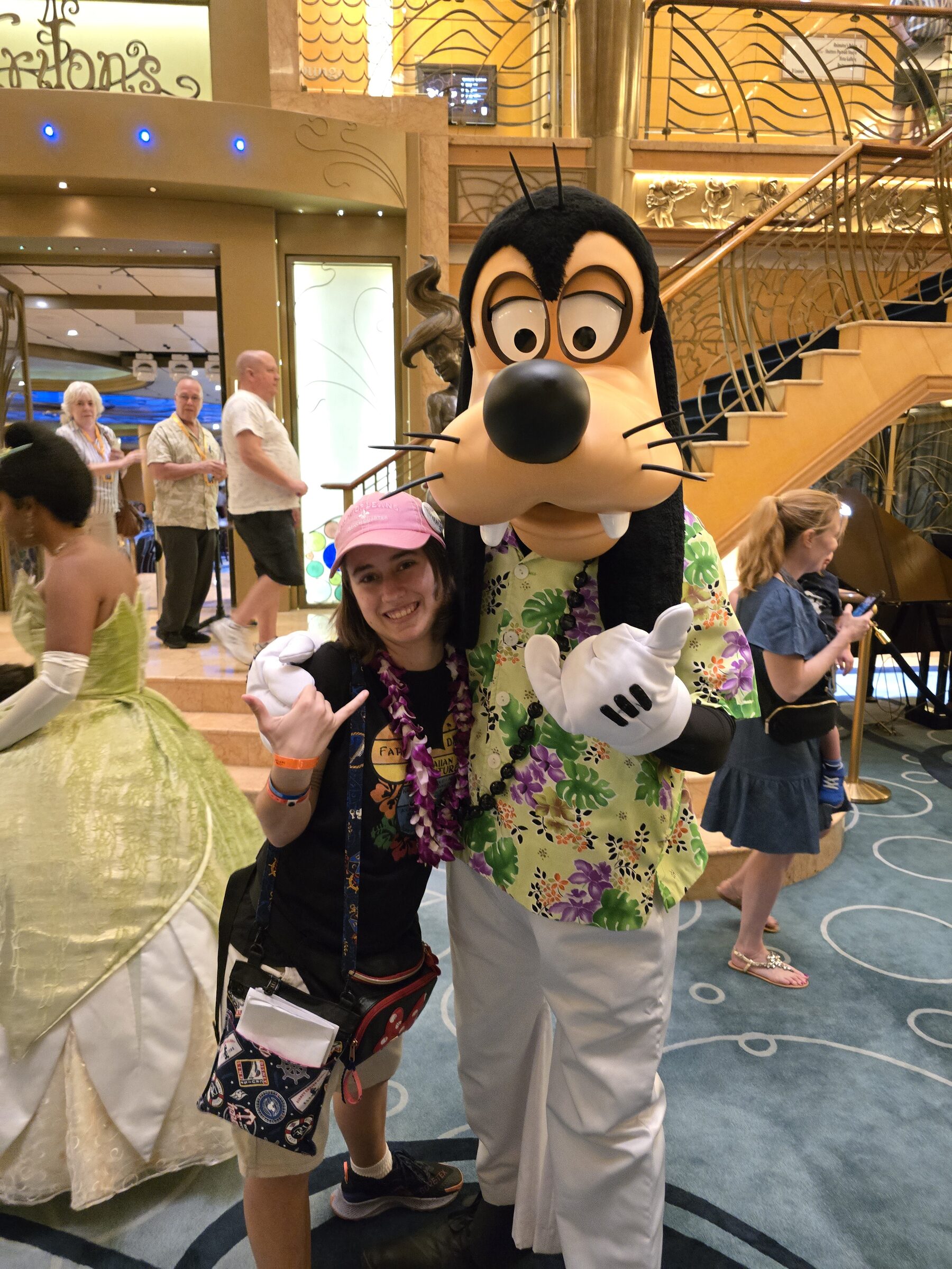 Lisa with Goofy in his aloha shirt and lei in the Lobby Atrium, Tiana behind them