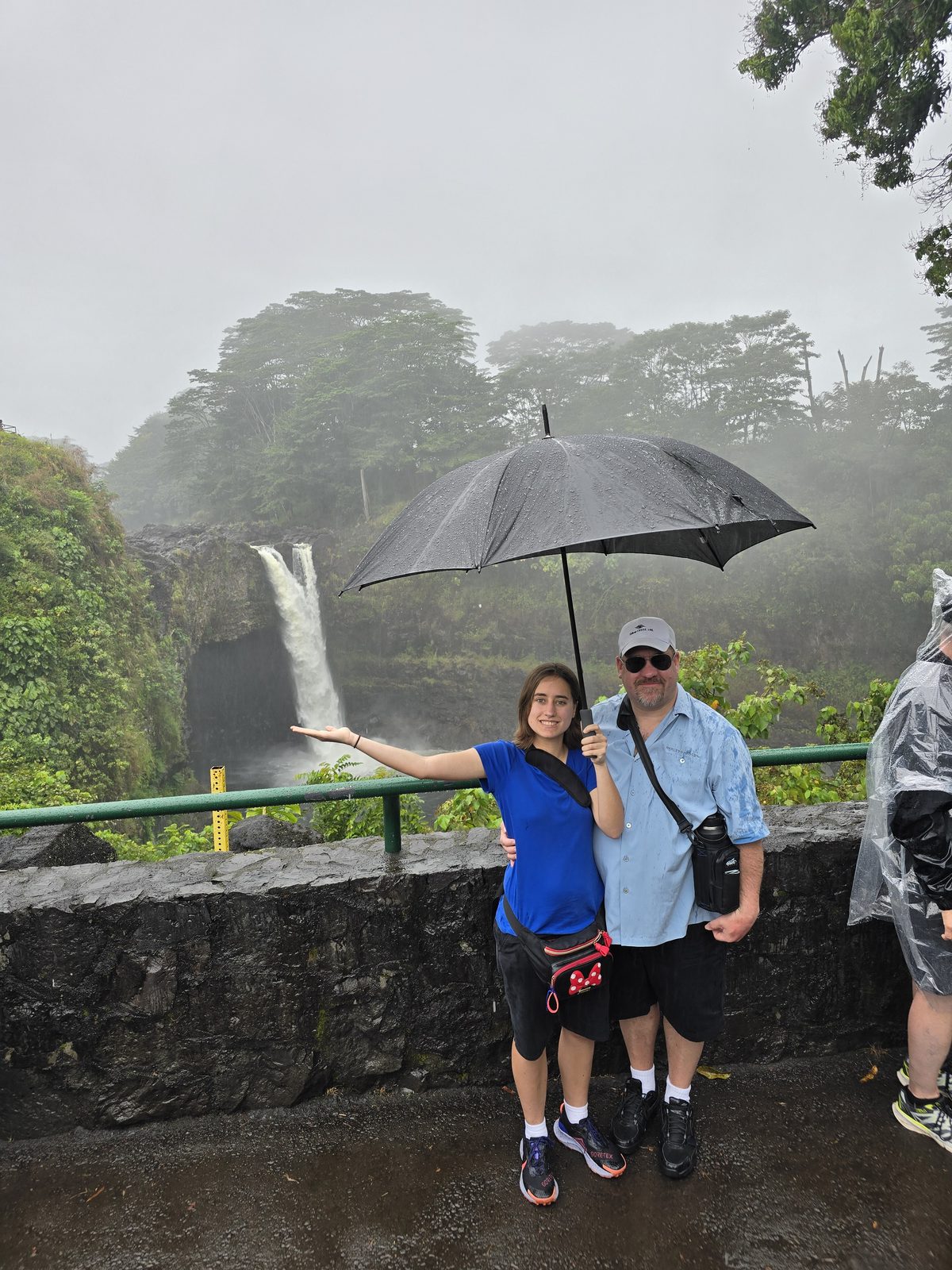 Sharing one umbrella at Rainbow Falls