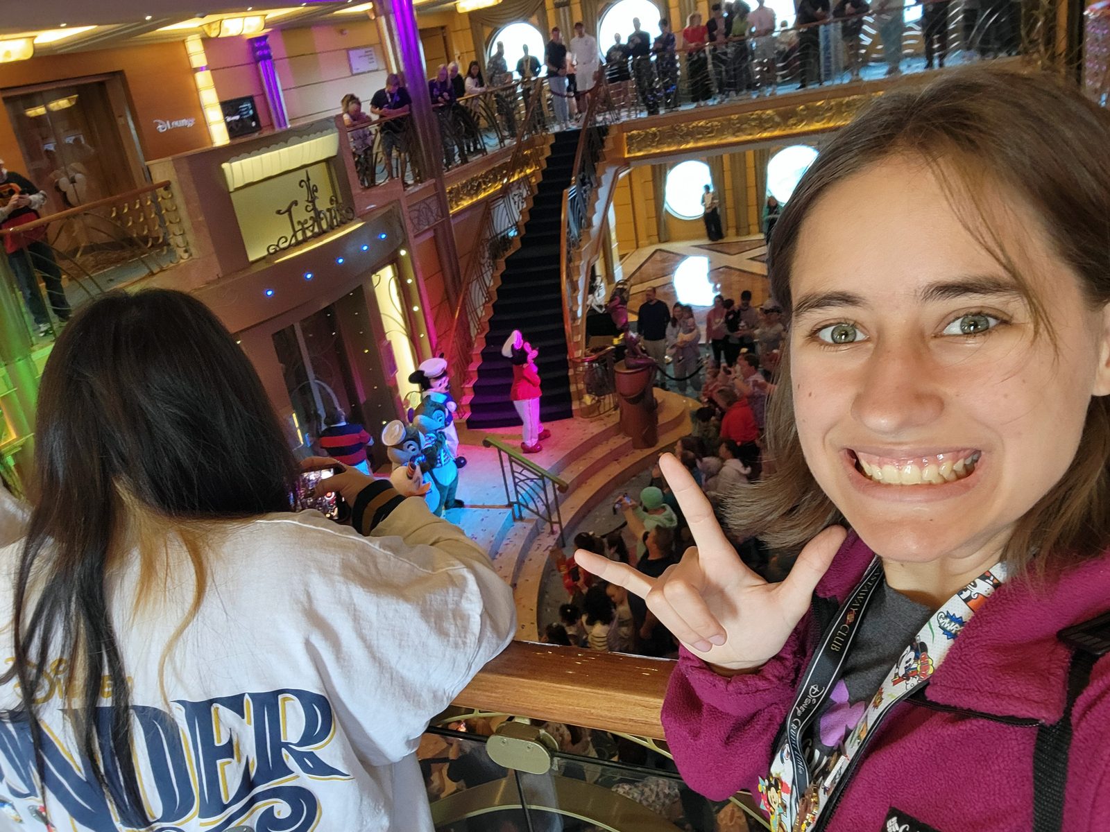 Lisa signs I love you from the atrium balcony