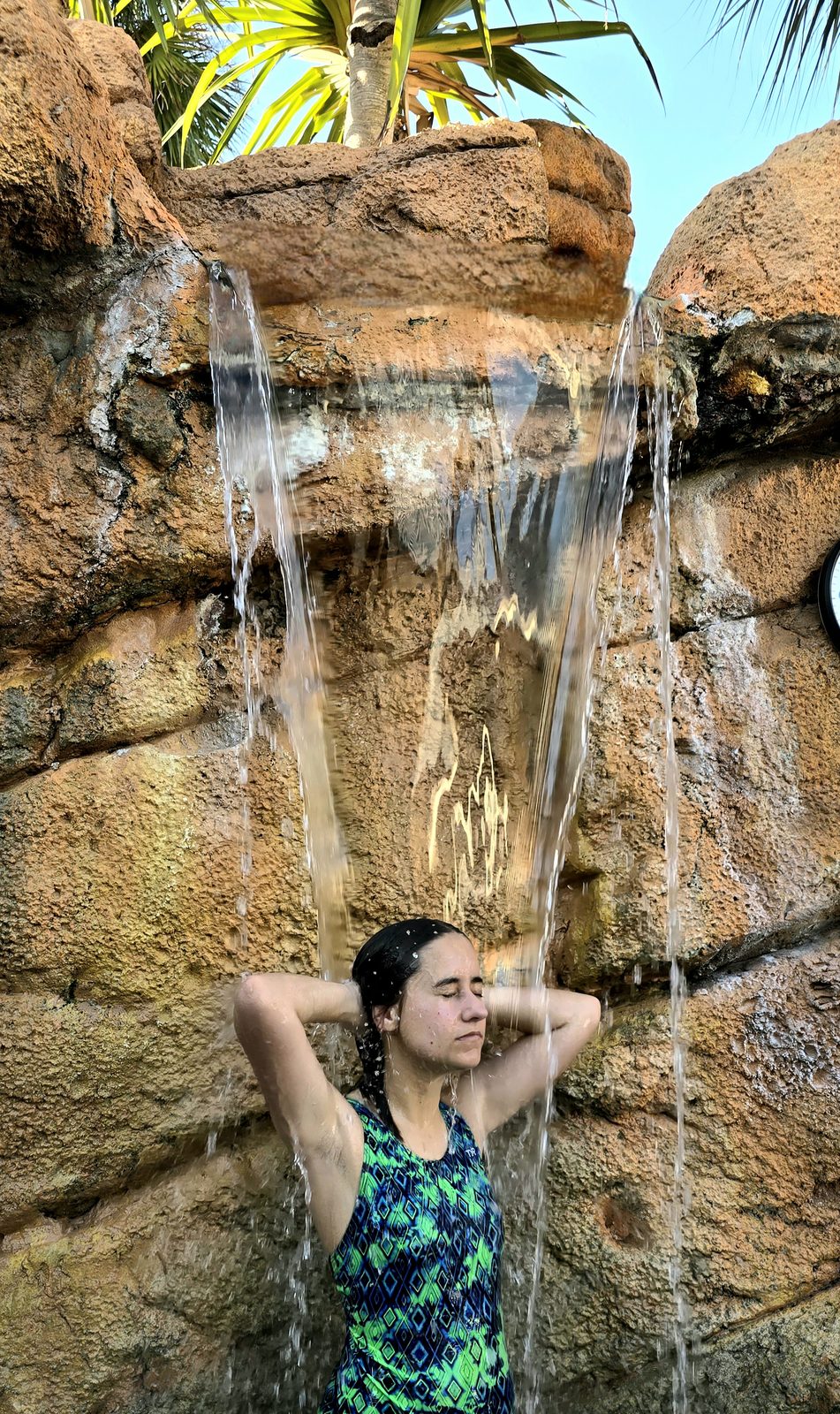Lisa cooling off under the hotel pool waterfall