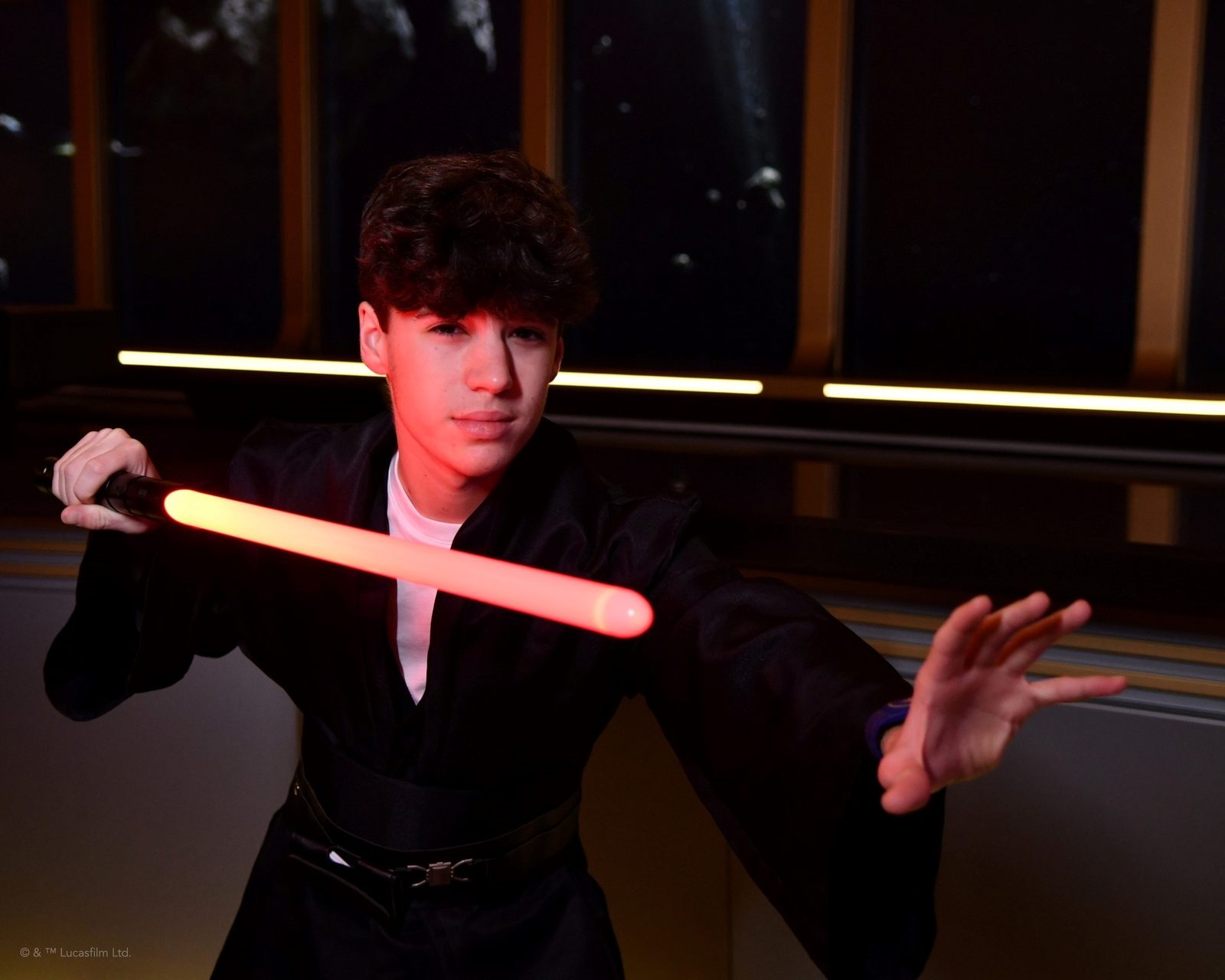 Thomas with a lightsaber in the Hyperspace Lounge