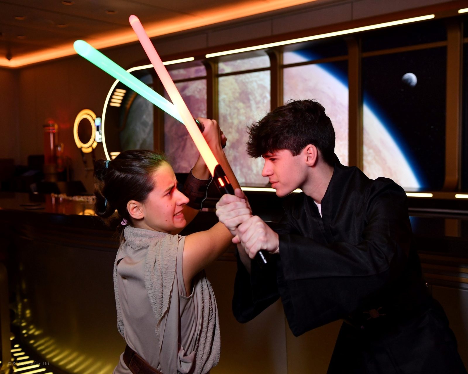 Lisa and Thomas lightsaber dueling in the Hyperspace Lounge