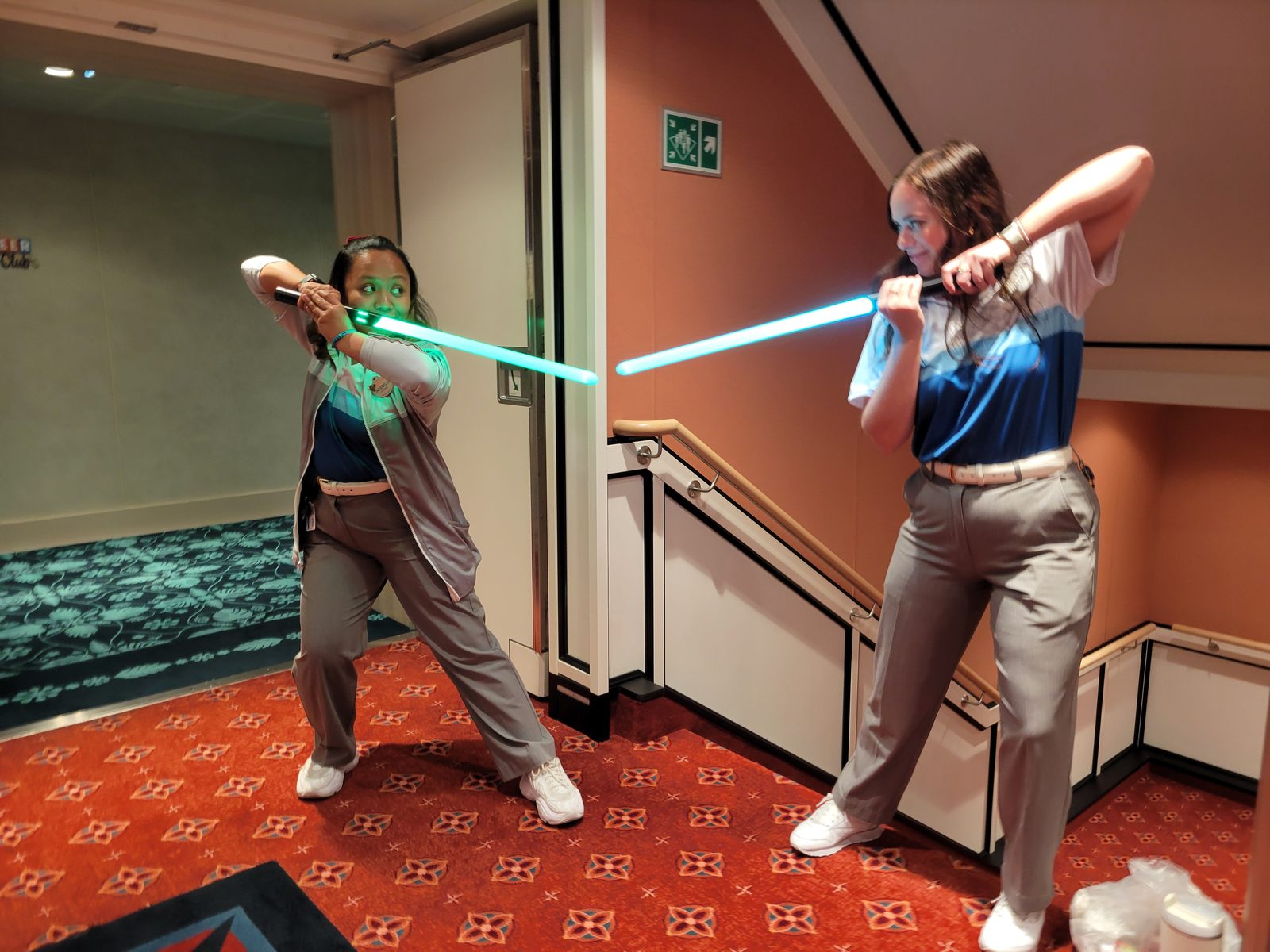 A lightsaber duel with training sabers by the stairs