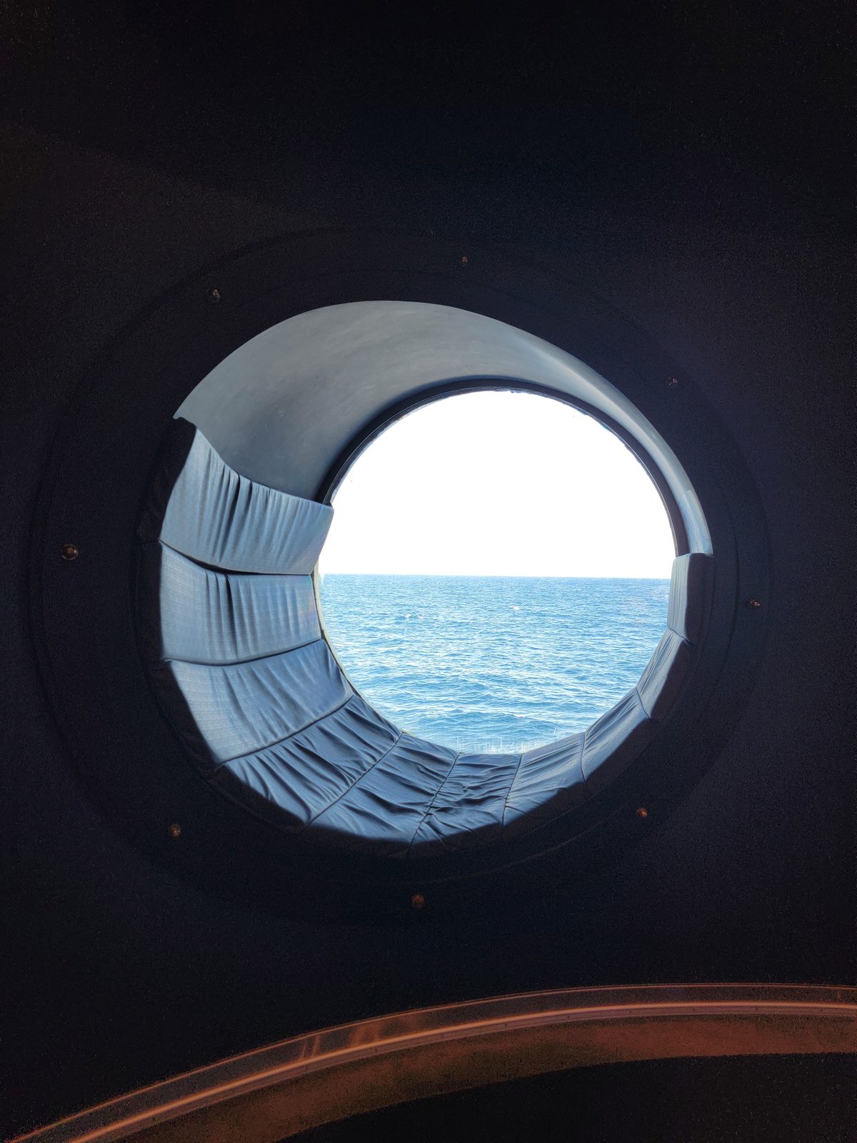 A porthole view of the ocean on their sea day