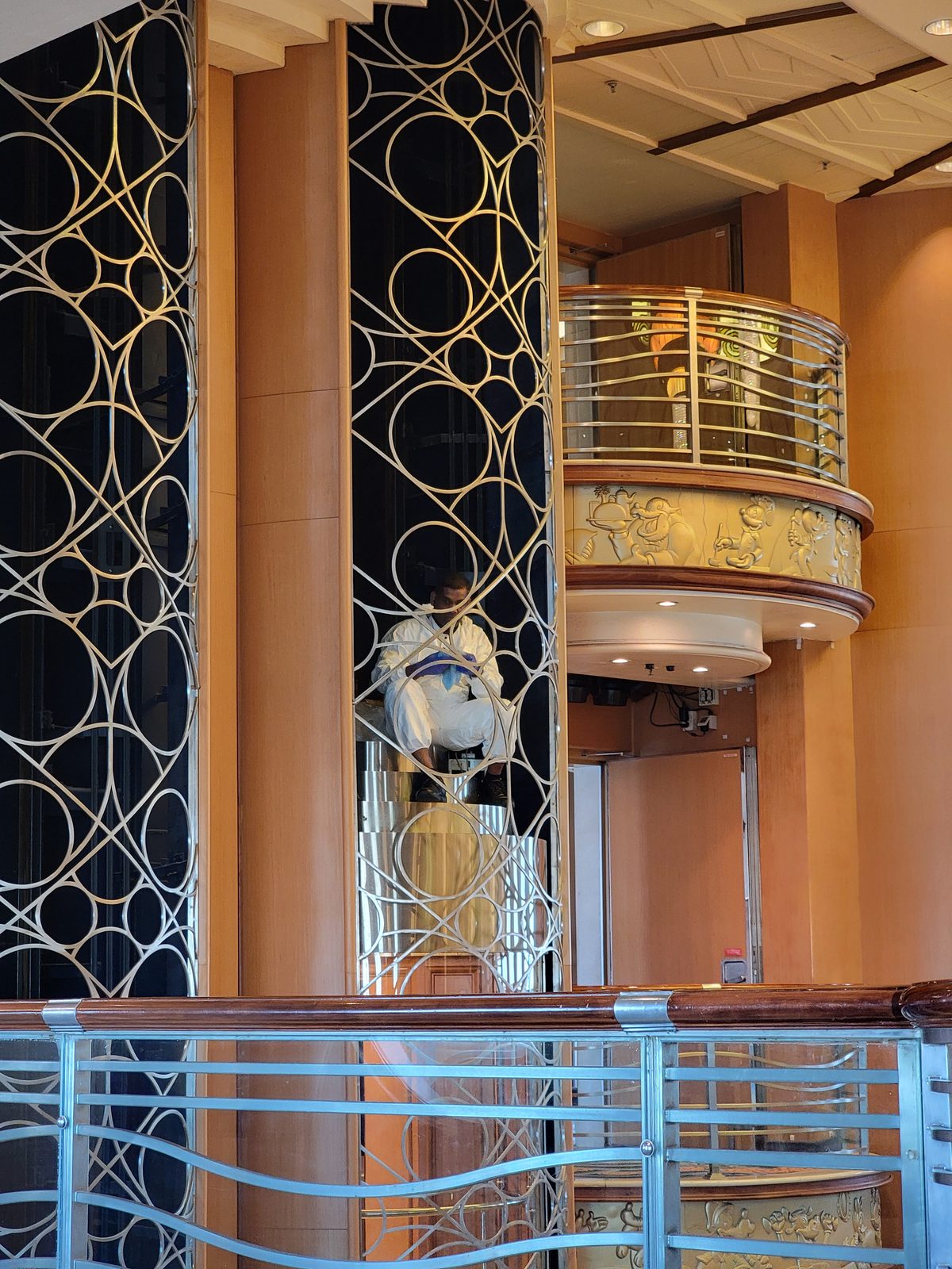 A Cast Member dusting the top of the elevator