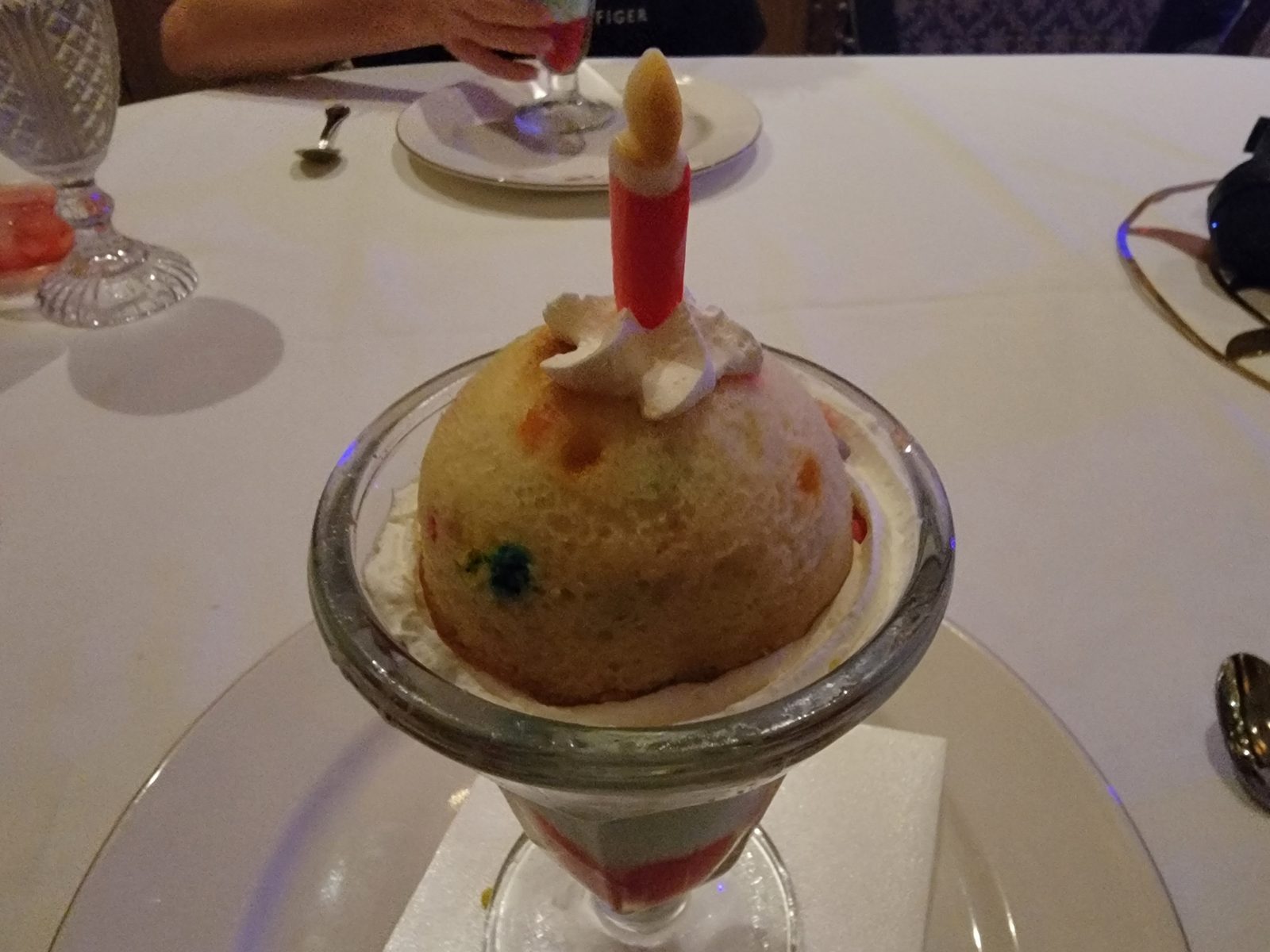 A sundae arrives with a lit candle
