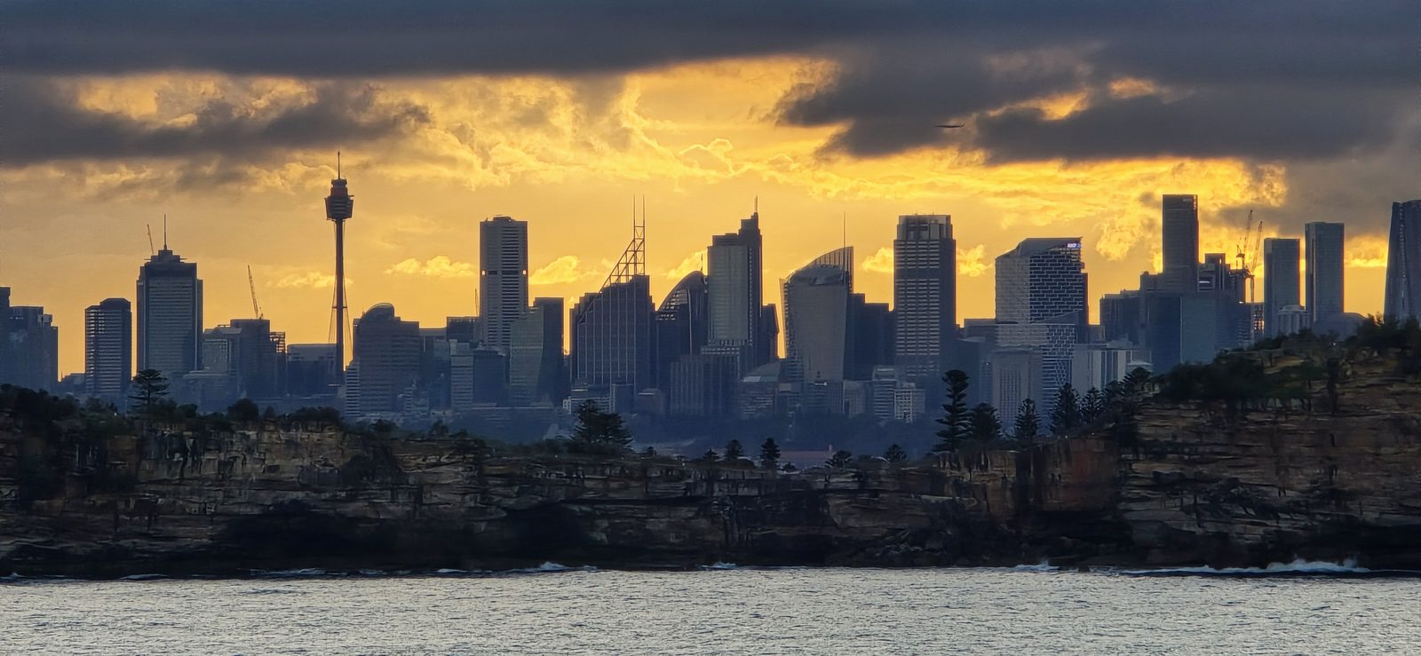 Sydney fades to a dark shape against the sunset