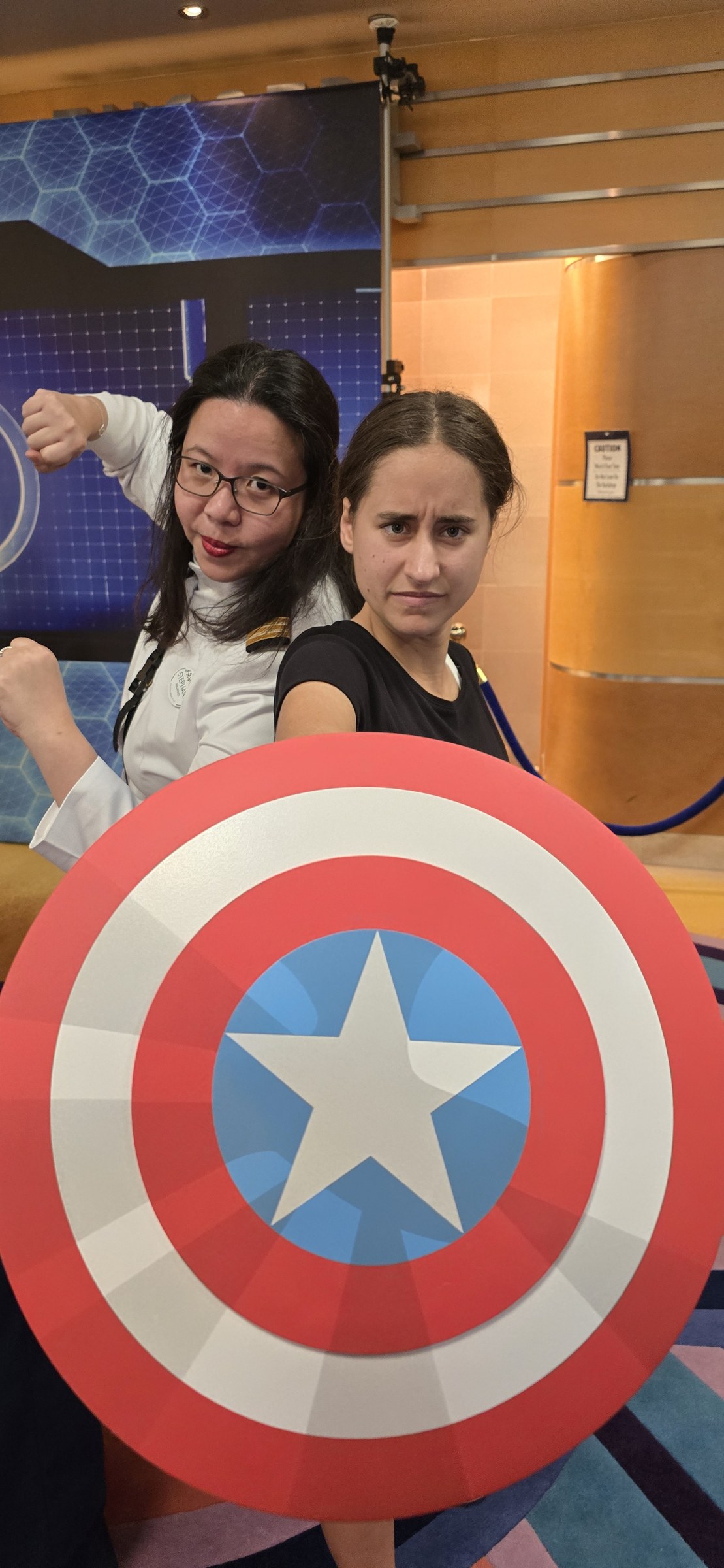 Stephanie, one of the ship's officers, and Lisa taking cover behind Captain America's shield