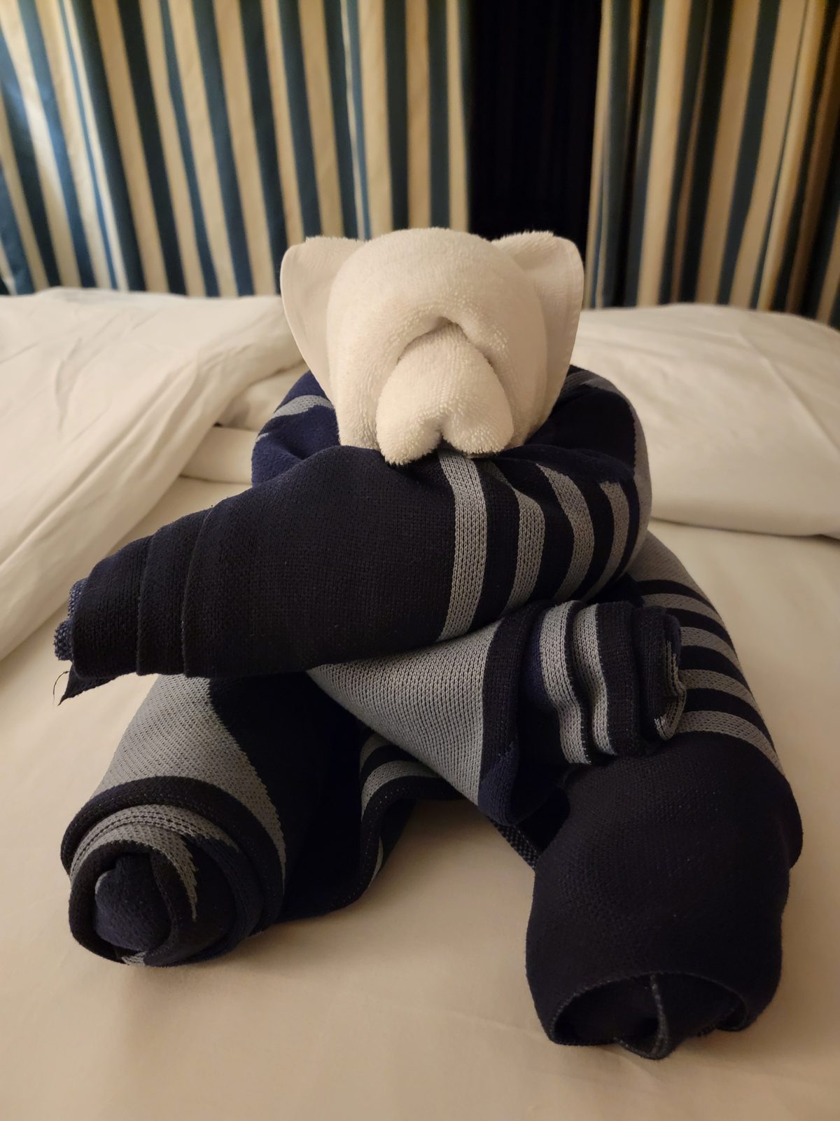 A towel dog waits on the bed