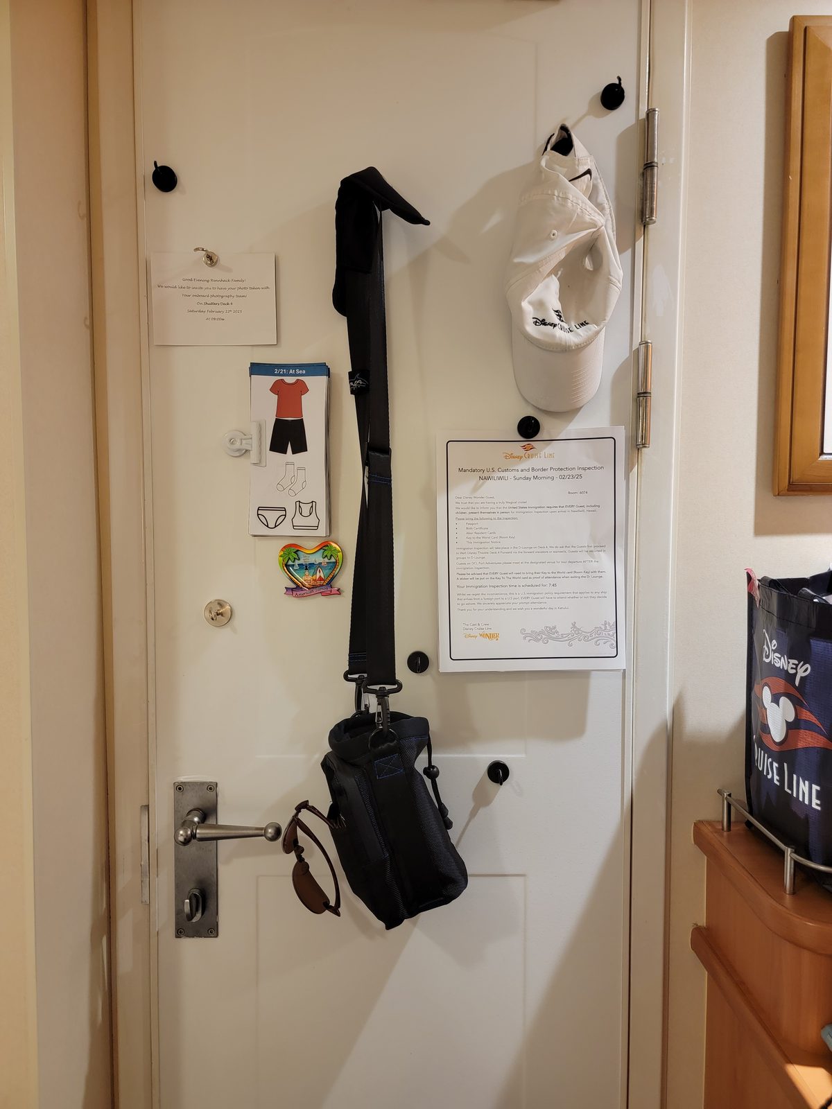 Our stateroom door with the bags and hats