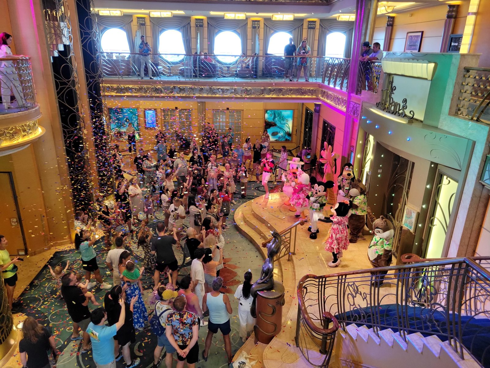 Mickey and friends in aloha wear dance in the Lobby Atrium under the confetti