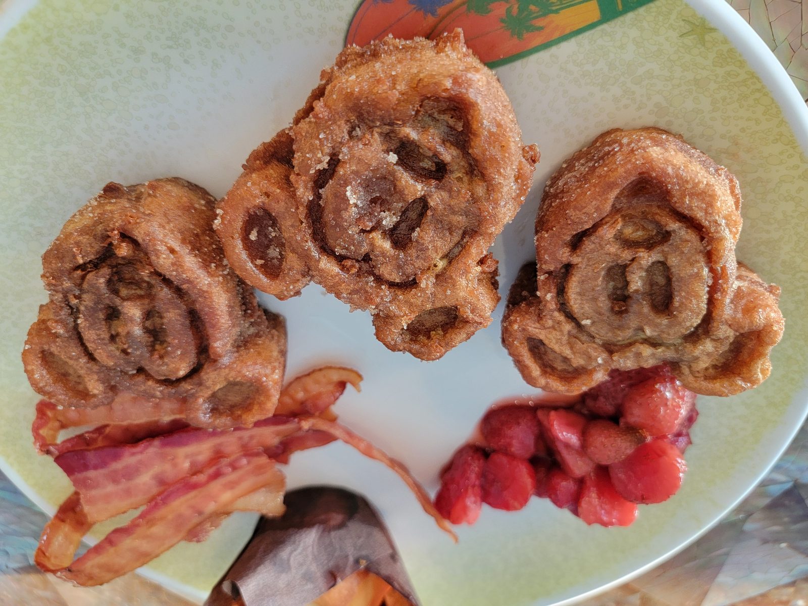 Mickey-shaped cinnamon rolls with bacon and strawberries