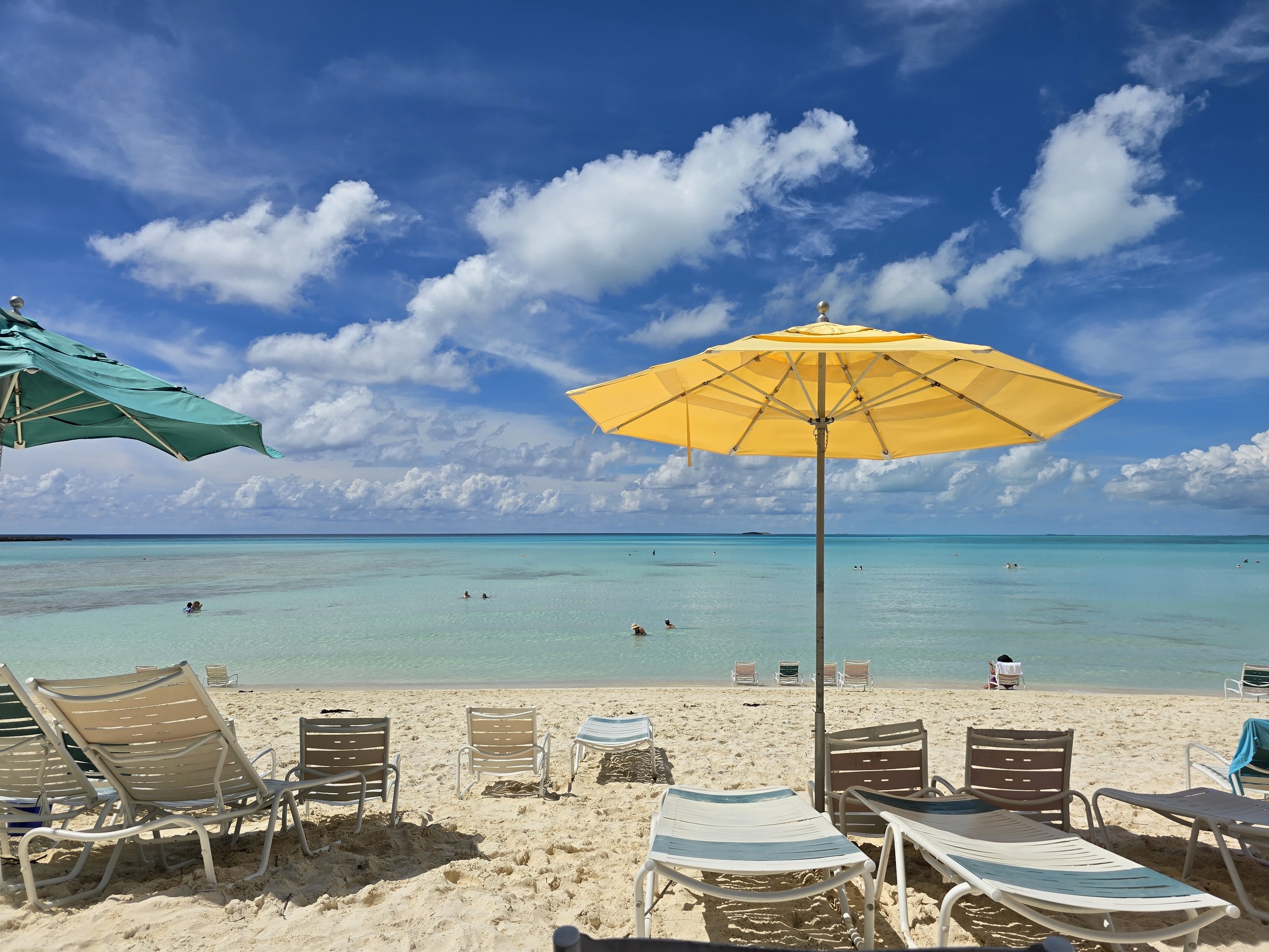 A yellow umbrella on the beach at Castaway Cay