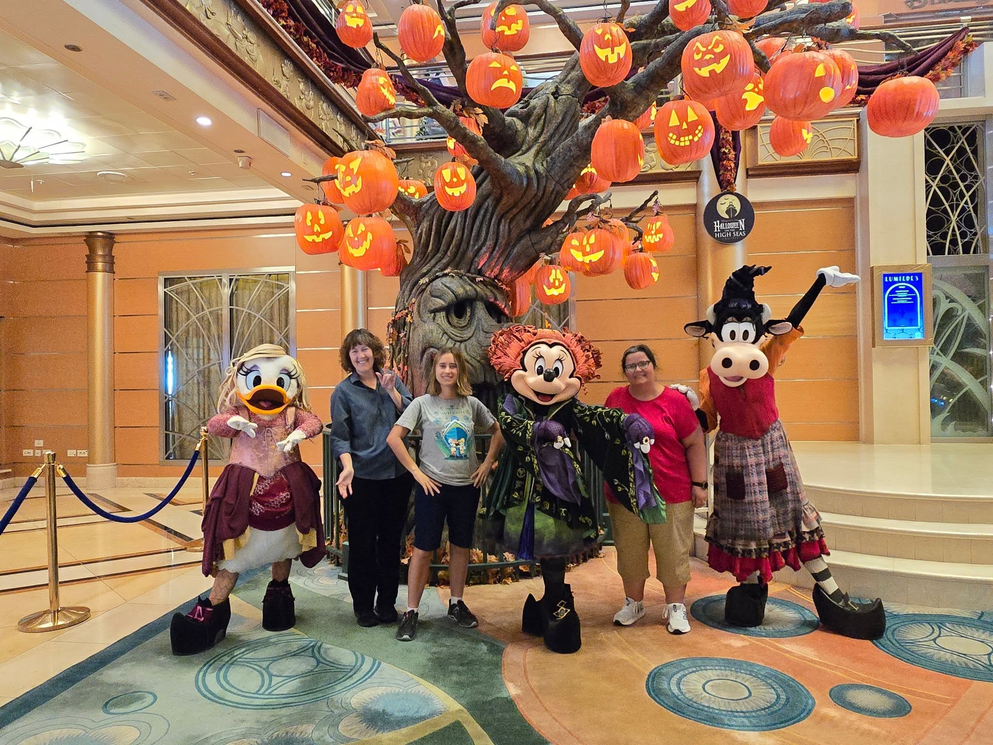 Daisy, Minnie & Clarabelle in their Sanderson Sisters Halloween costumes with Kathy & Lisa under Reap the Pumpkin Tree