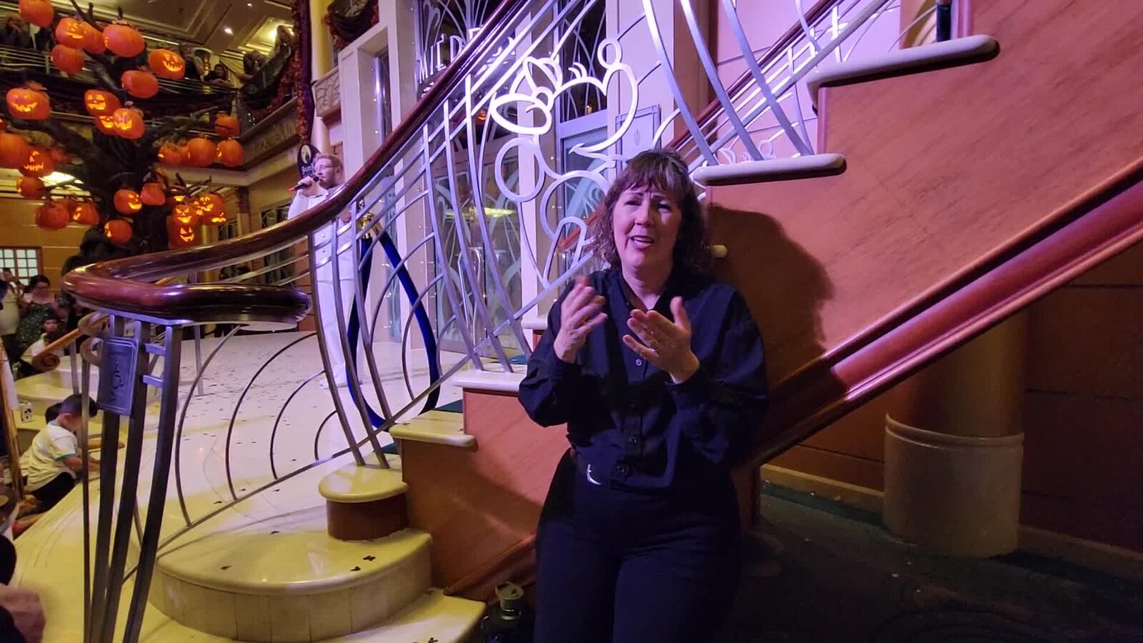 An ASL interpreter signing the character parade in the atrium
