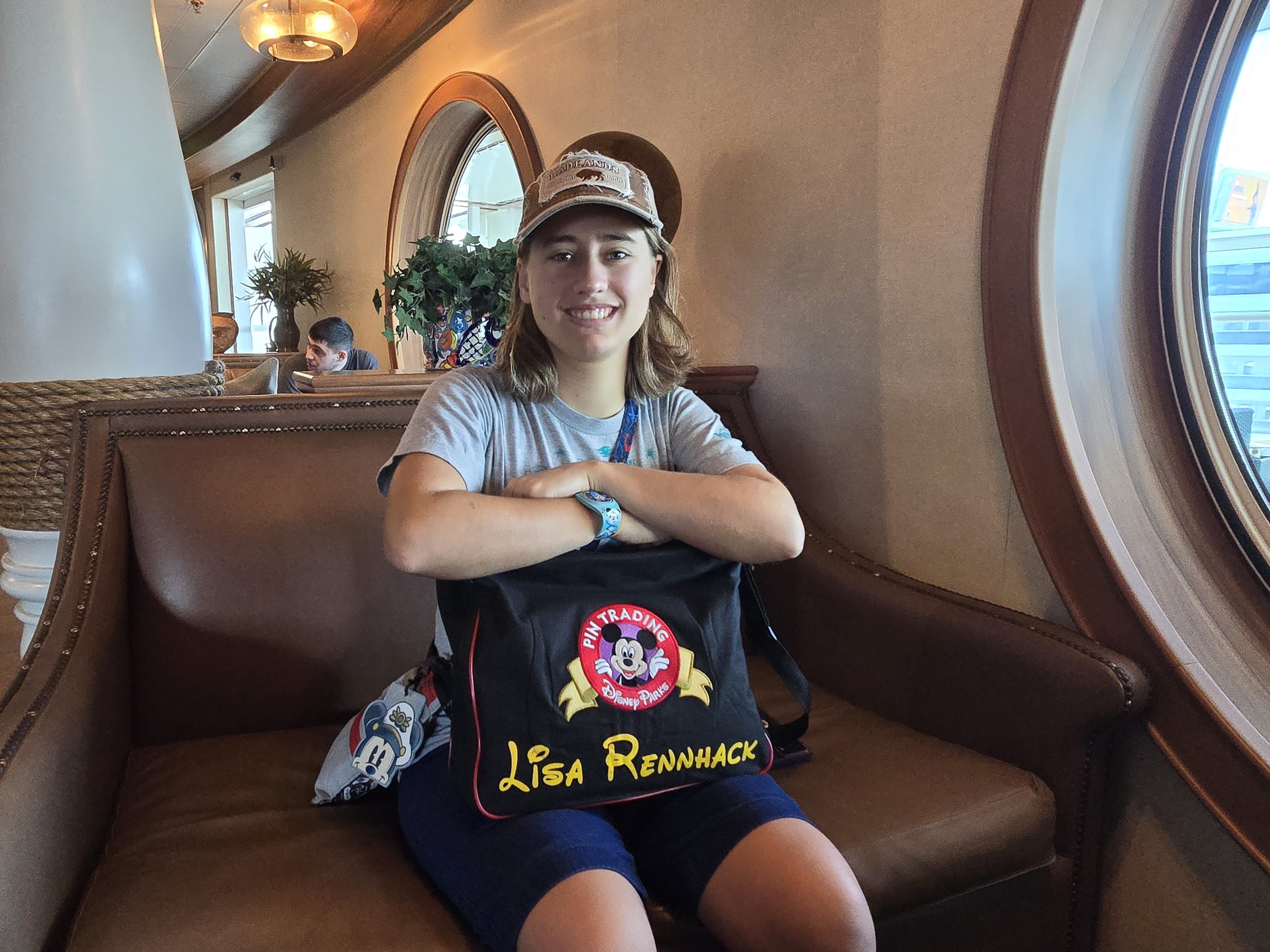 Lisa by a porthole with her Mickey bag