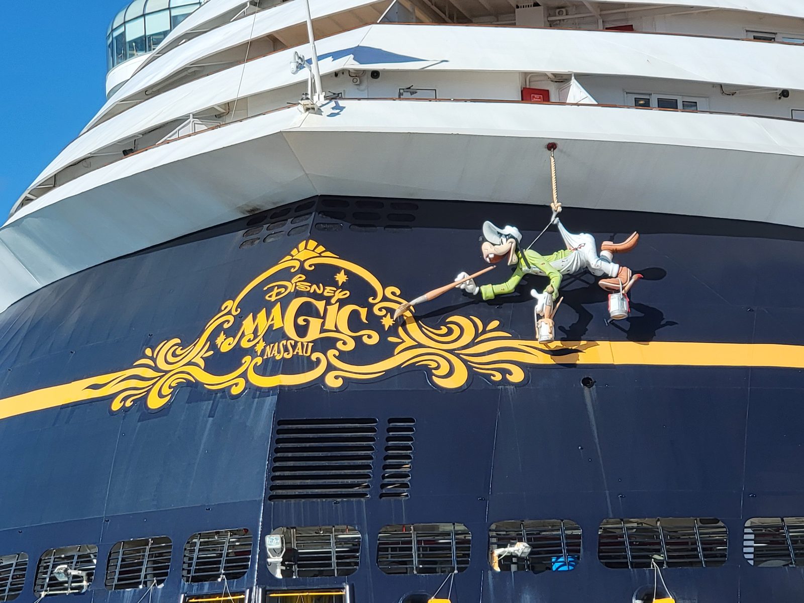 Goofy hangs from the Disney Magic's bow