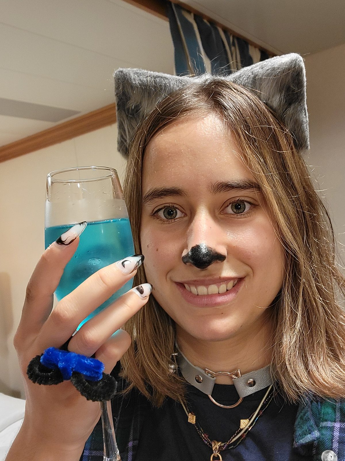Lisa in cat makeup with a blue mocktail