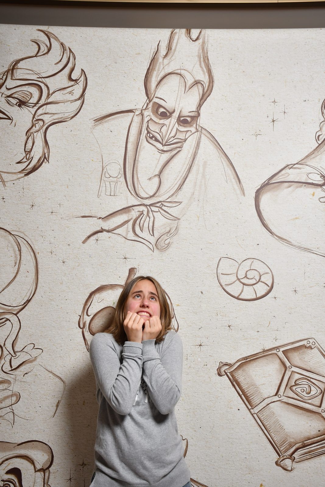 Lisa plays scared under a sketch of Hades