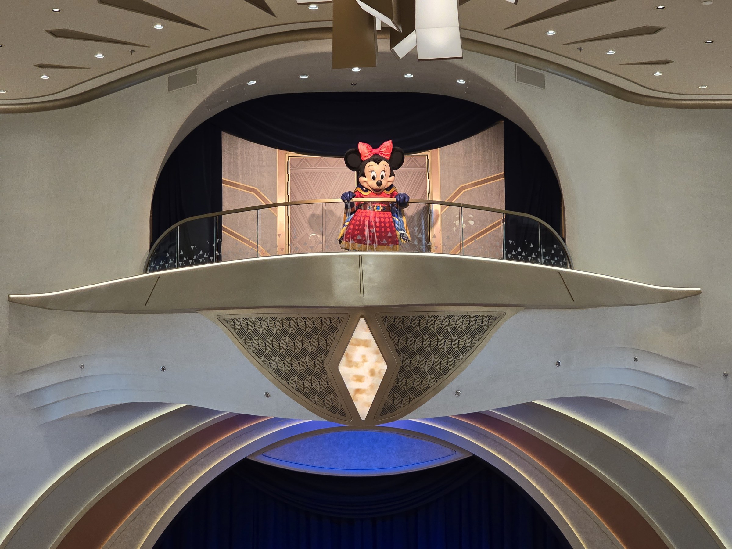 Hero Minnie waving from the balcony in the Grand Hall