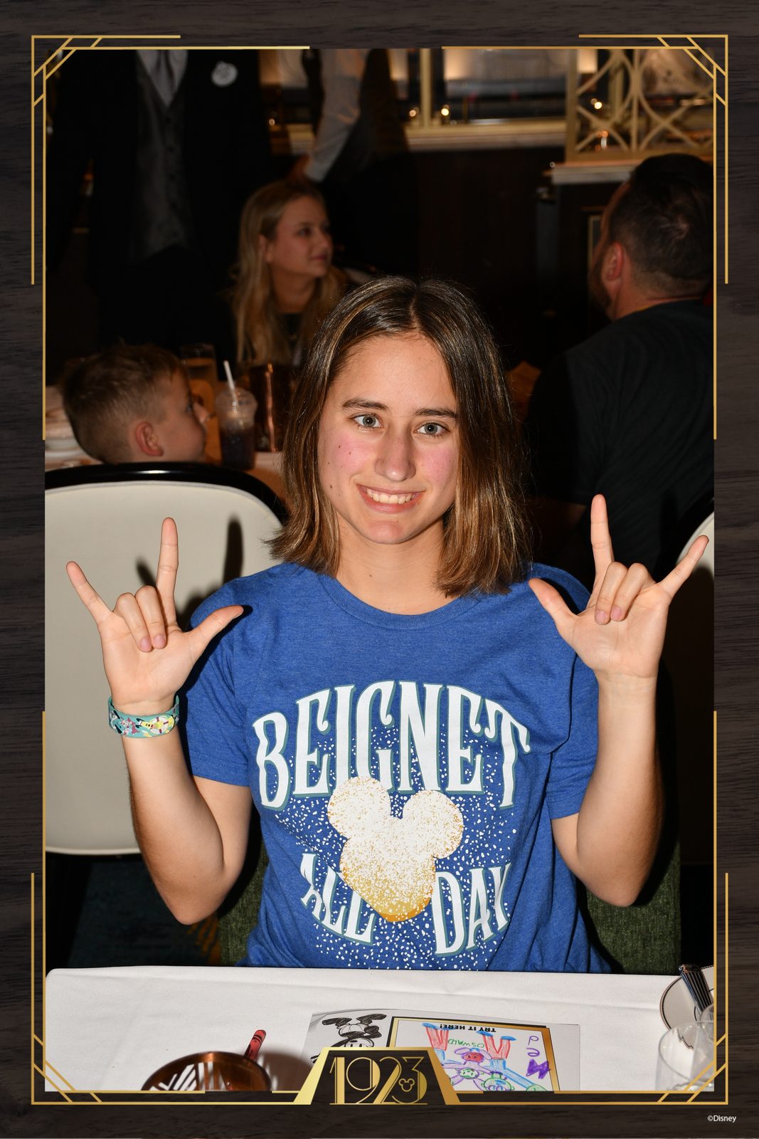 Lisa signing I love you in her Beignet shirt