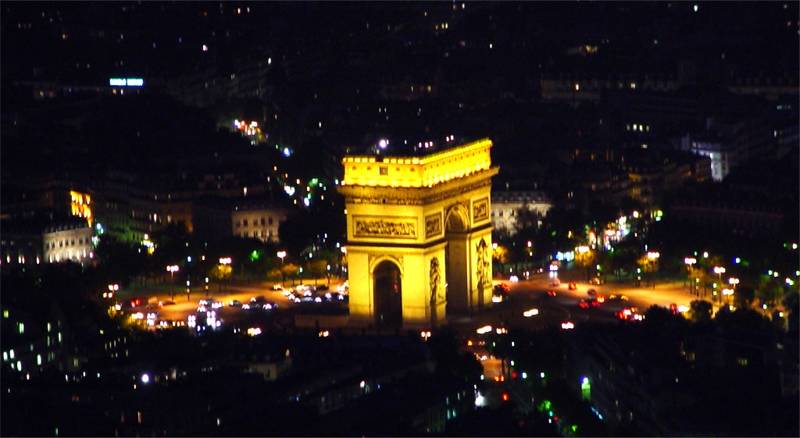 The Arc de Triomphe lit up over Paris at night