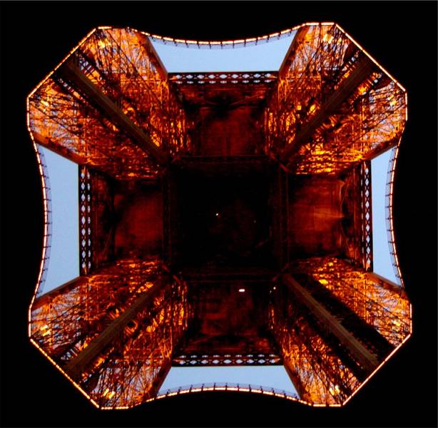 Looking straight up under the Eiffel Tower at night