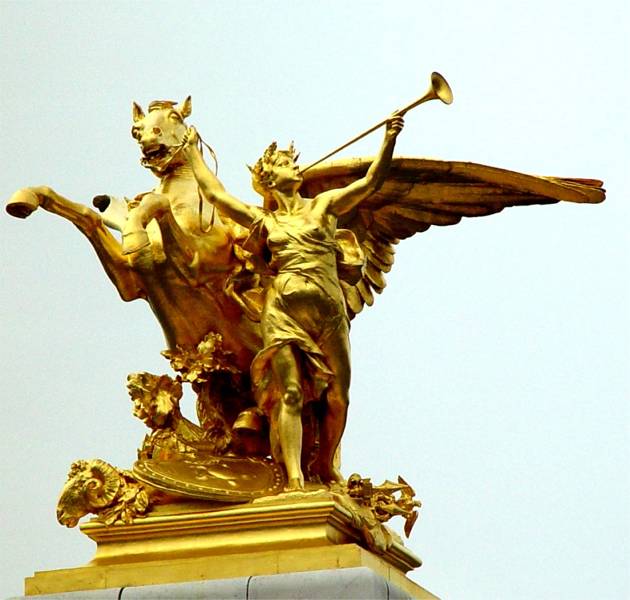 A golden statue with a trumpet near the Arc de Triomphe