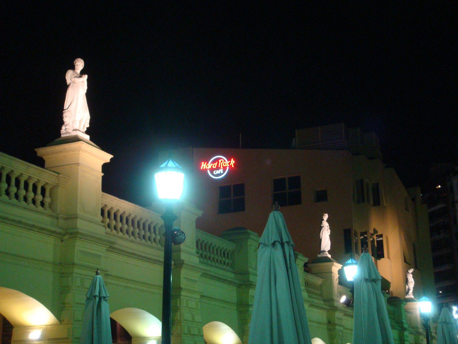Statues glowing green and gold above the Hard Rock Cafe