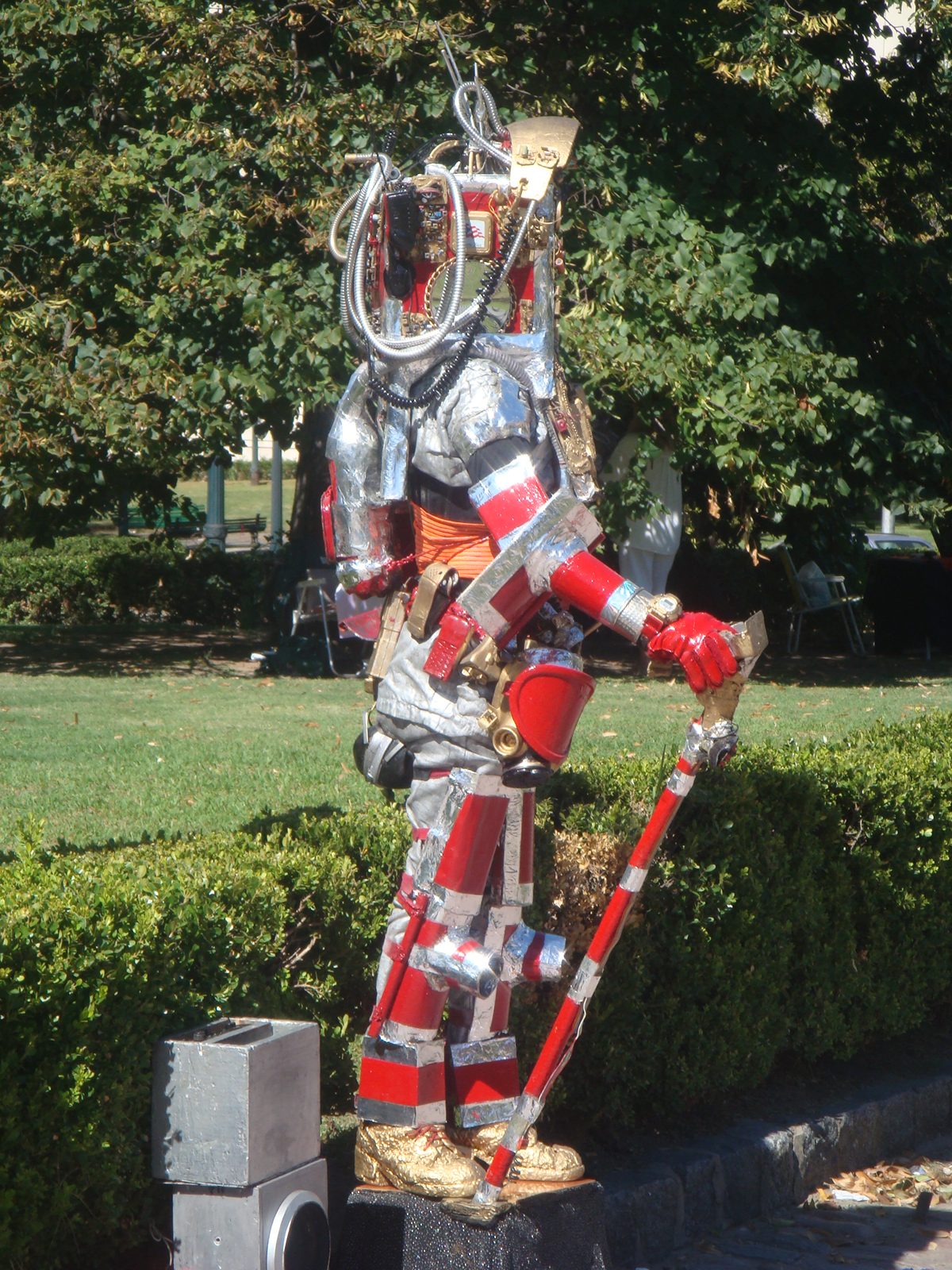 A silver and red robot costume in the park