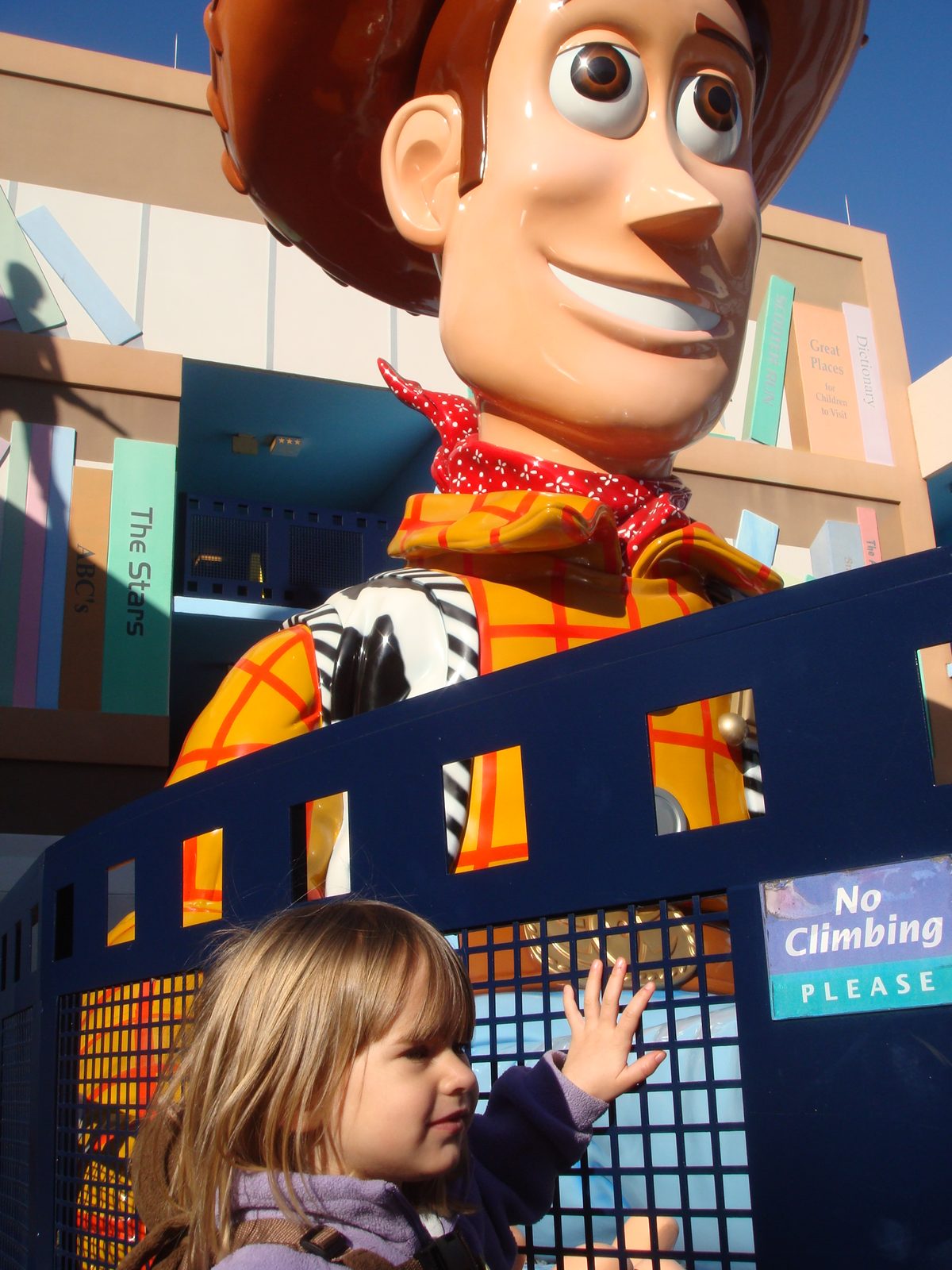 Lisa reaching up to the giant Woody statue