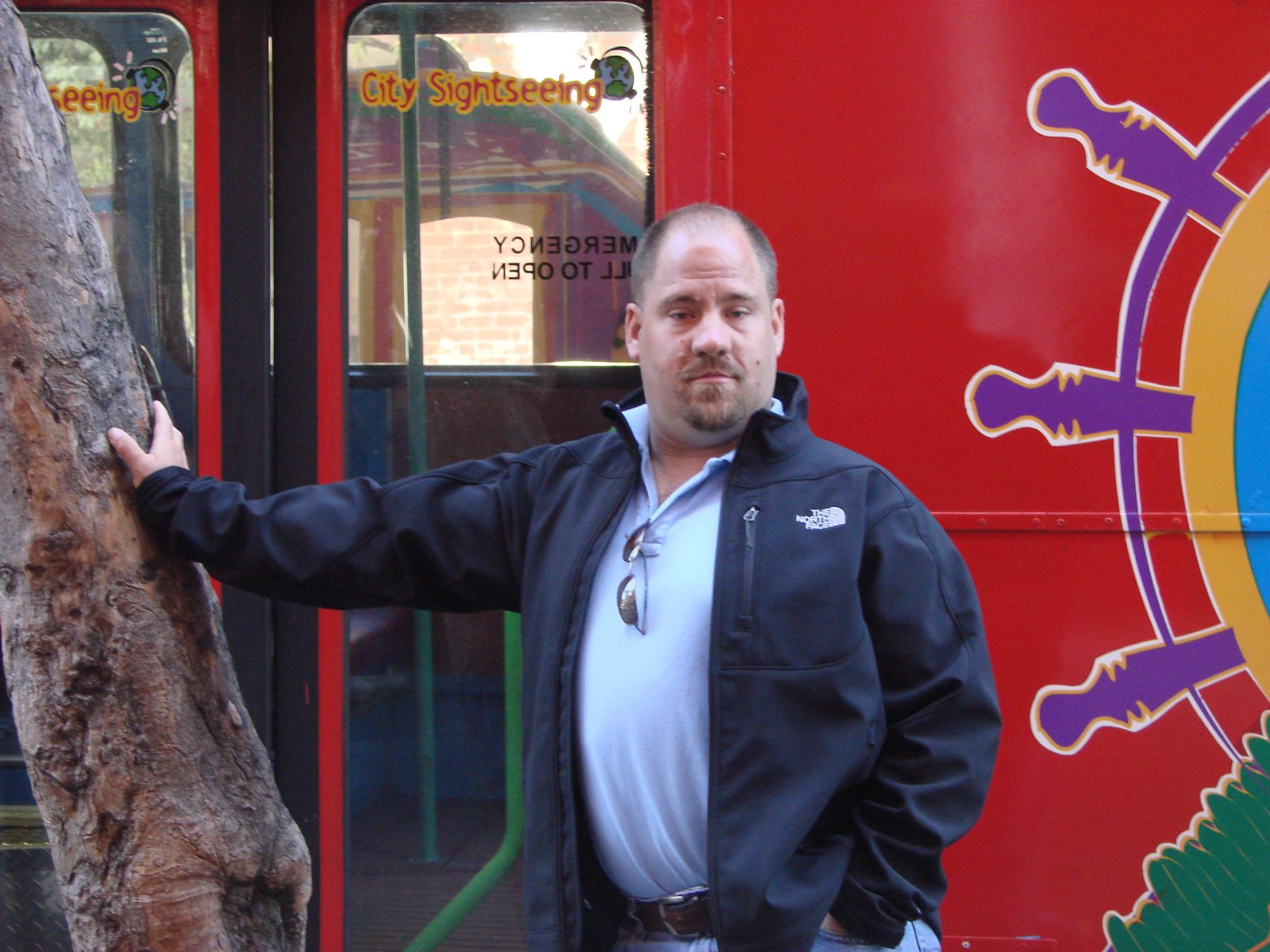 Me beside the red sightseeing bus downtown