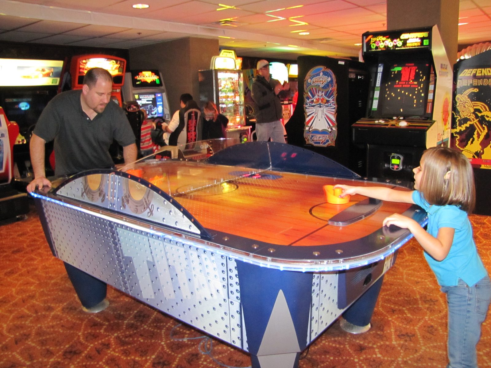 Lisa and Michael playing air hockey in the arcade