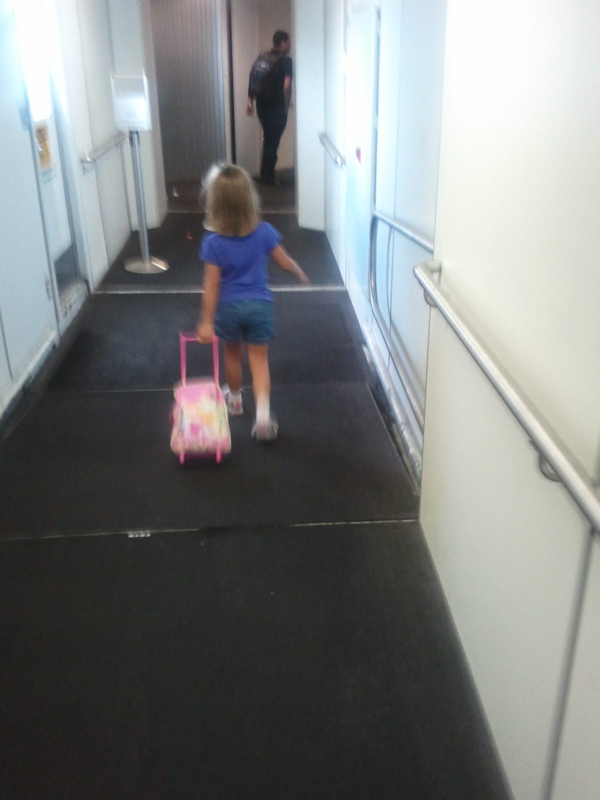 Lisa pulls her own suitcase down the hotel hallway