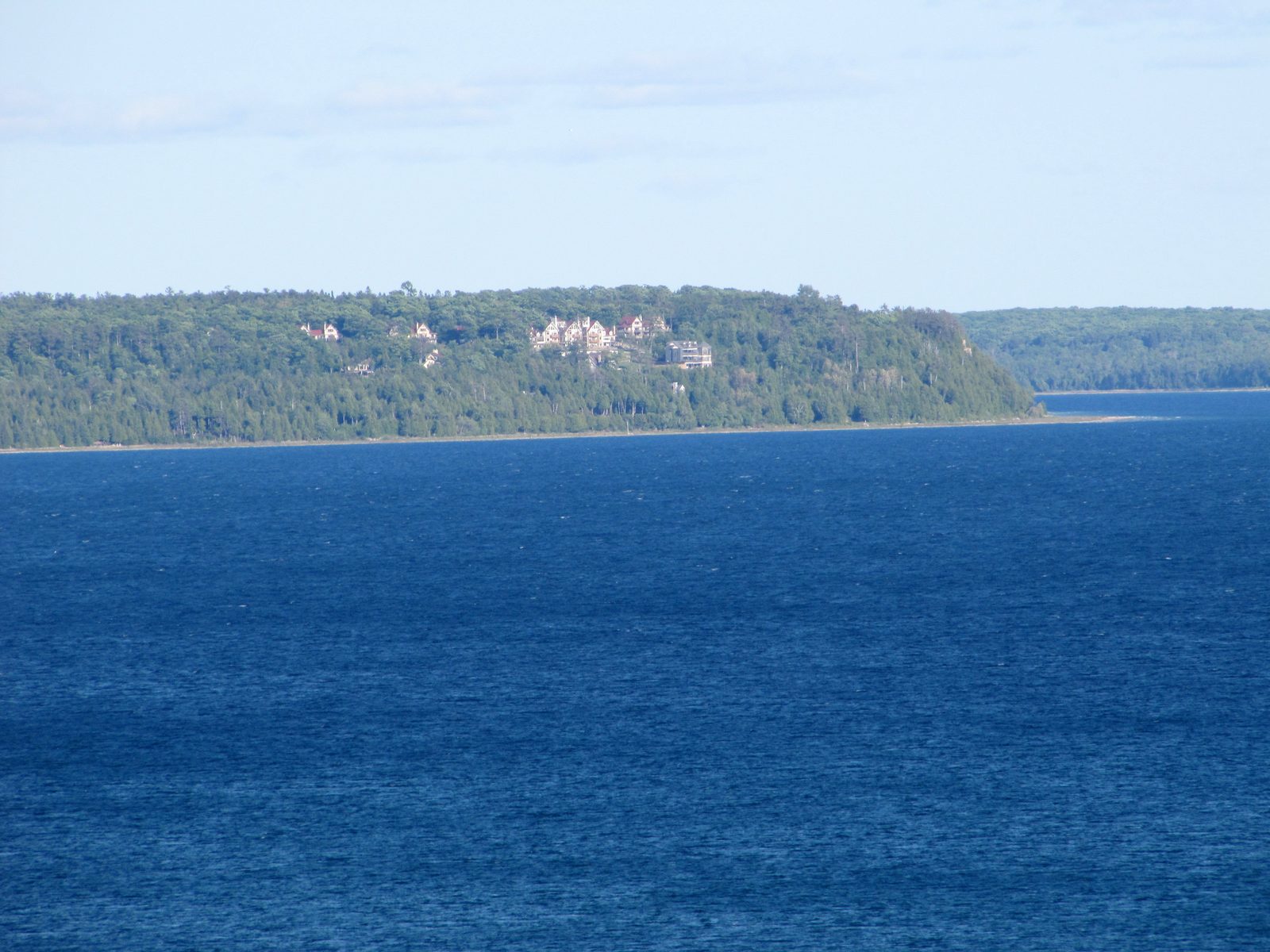 The wooded shoreline across the water