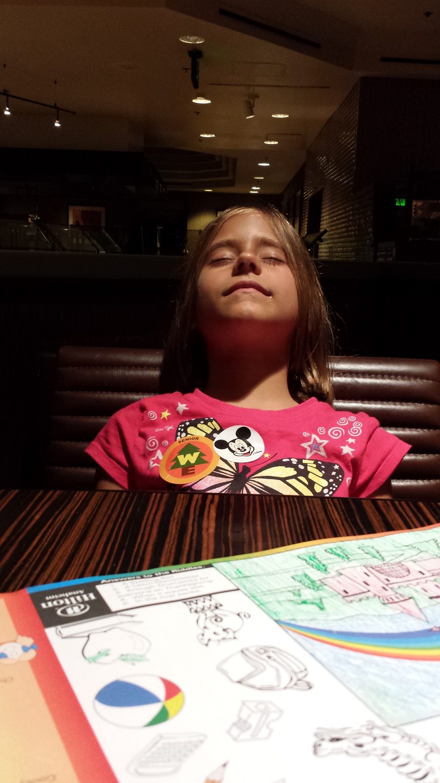 Coloring her placemat at dinner