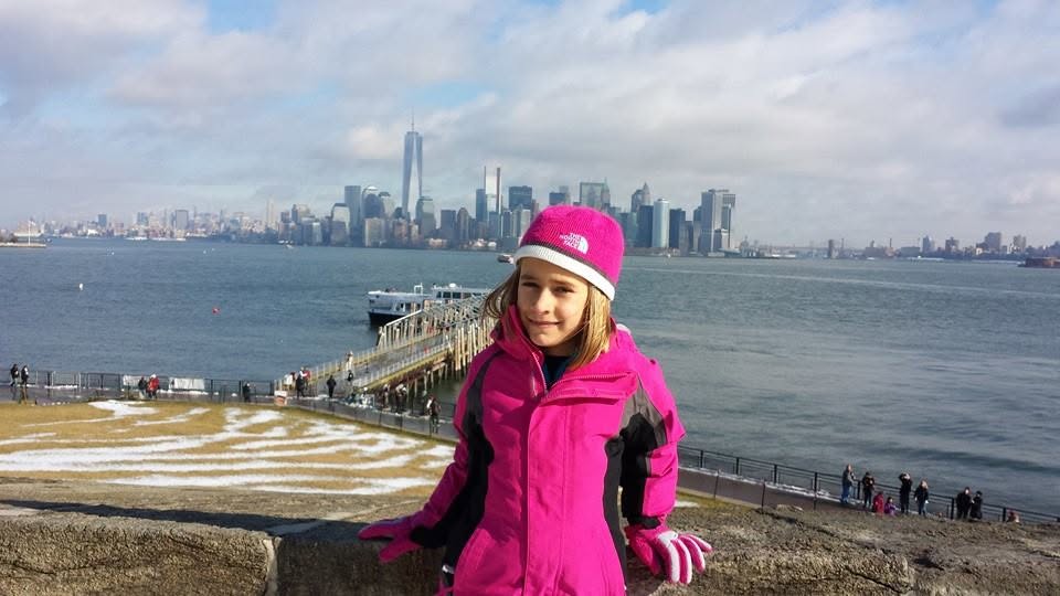 Lisa on Liberty Island with the Manhattan skyline