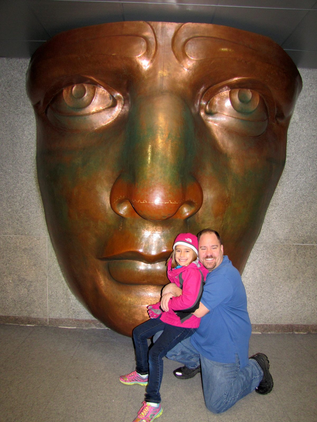 Lisa and Michael beside the giant Statue of Liberty face in the museum