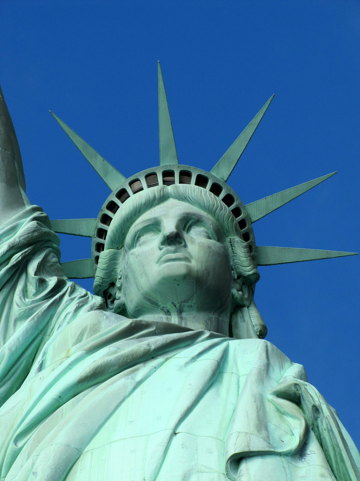 Lady Liberty's face against the blue sky