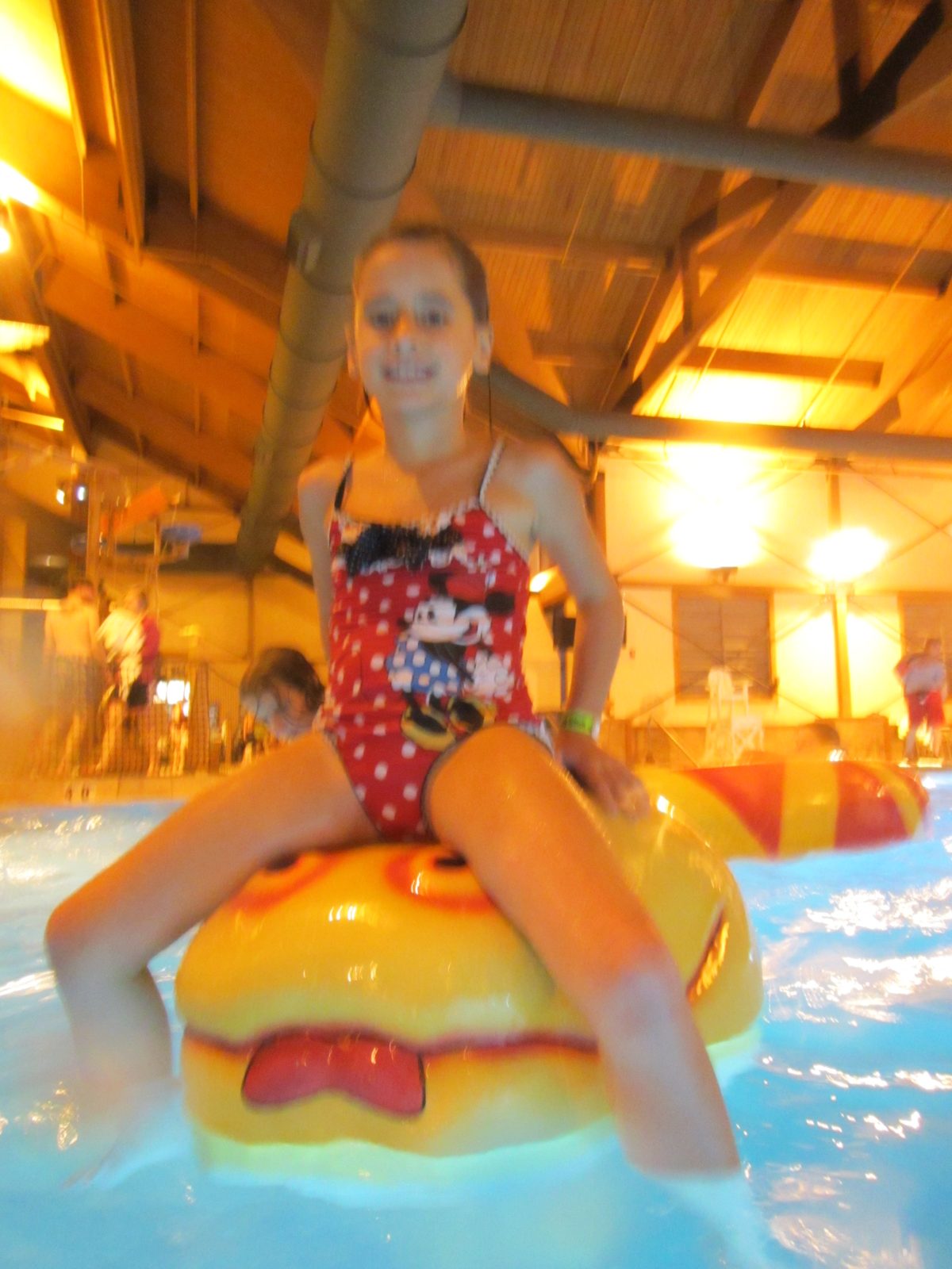 Lisa riding a burger-shaped pool float
