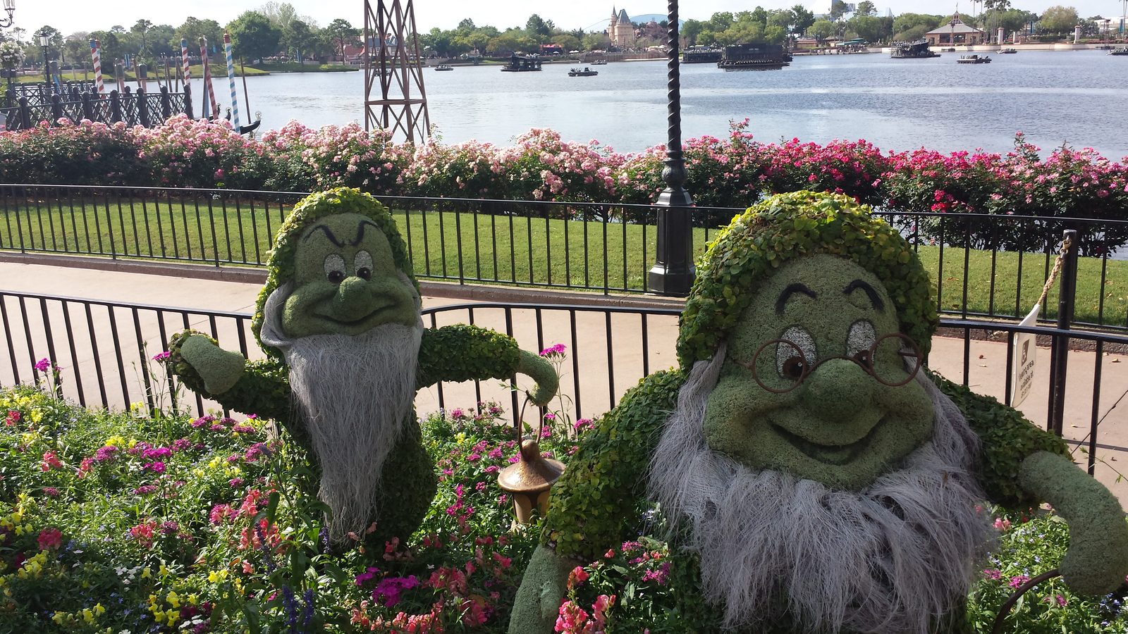 Two of the dwarfs in topiary by the Epcot lagoon