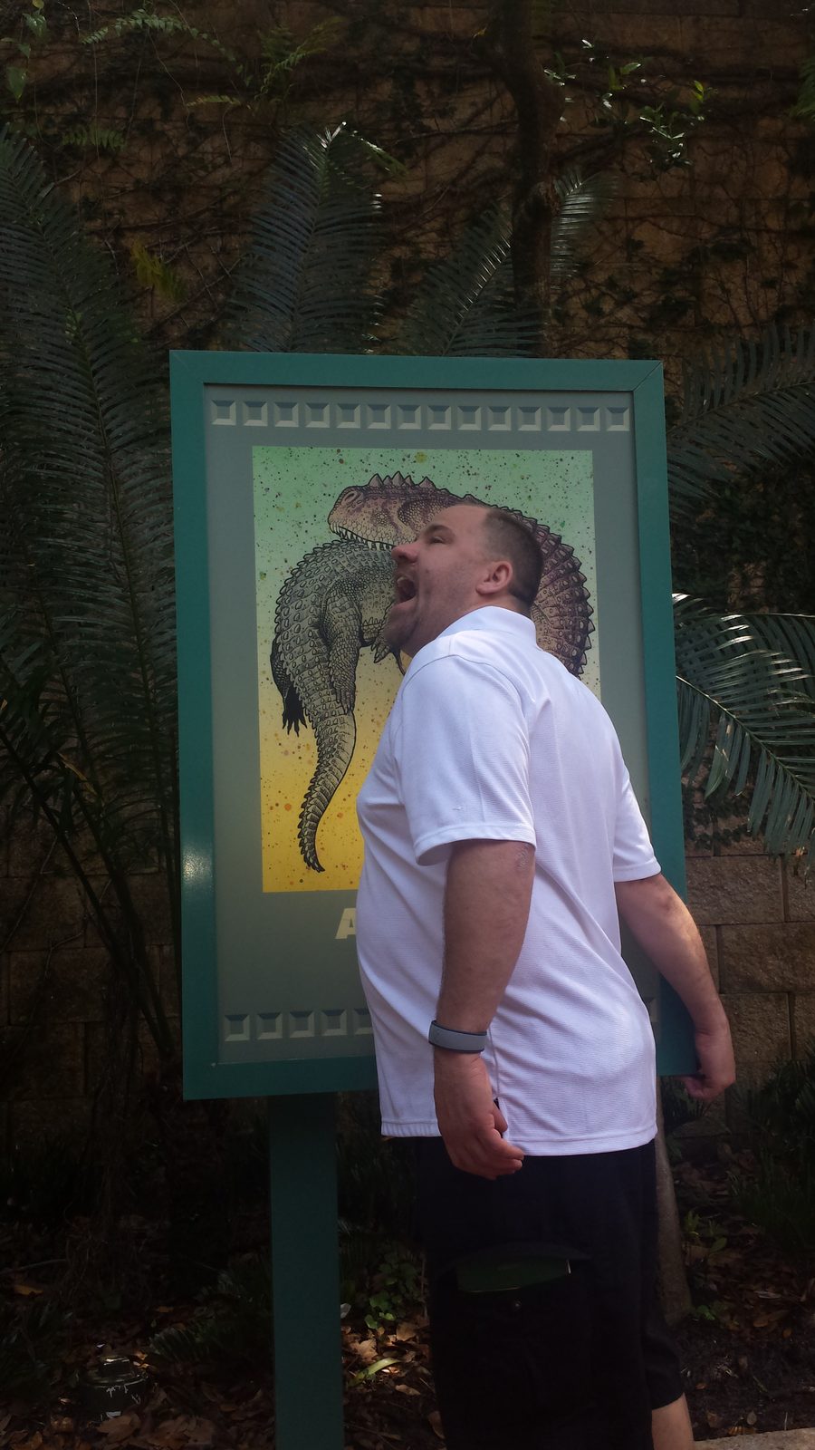Michael and a dinosaur sign in DinoLand