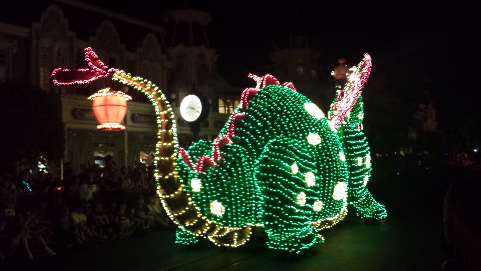 The Electrical Parade dragon lit up green and pink