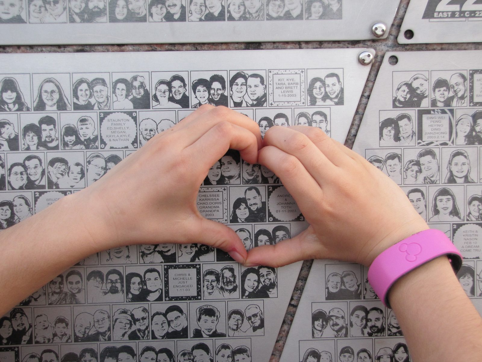 Making a heart over the wall of photos